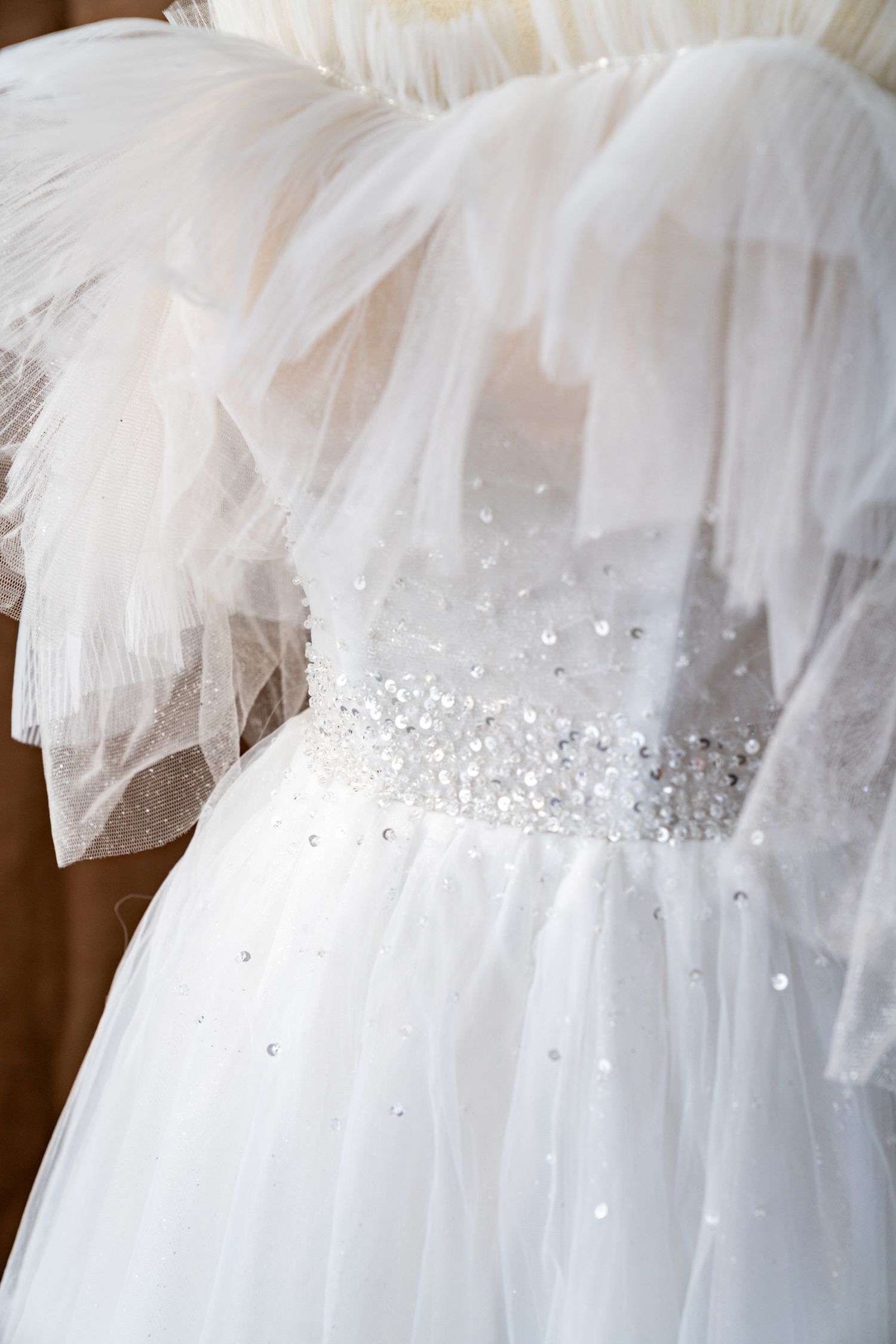 Sparkling beaded waistline detail on white tulle wedding dress.