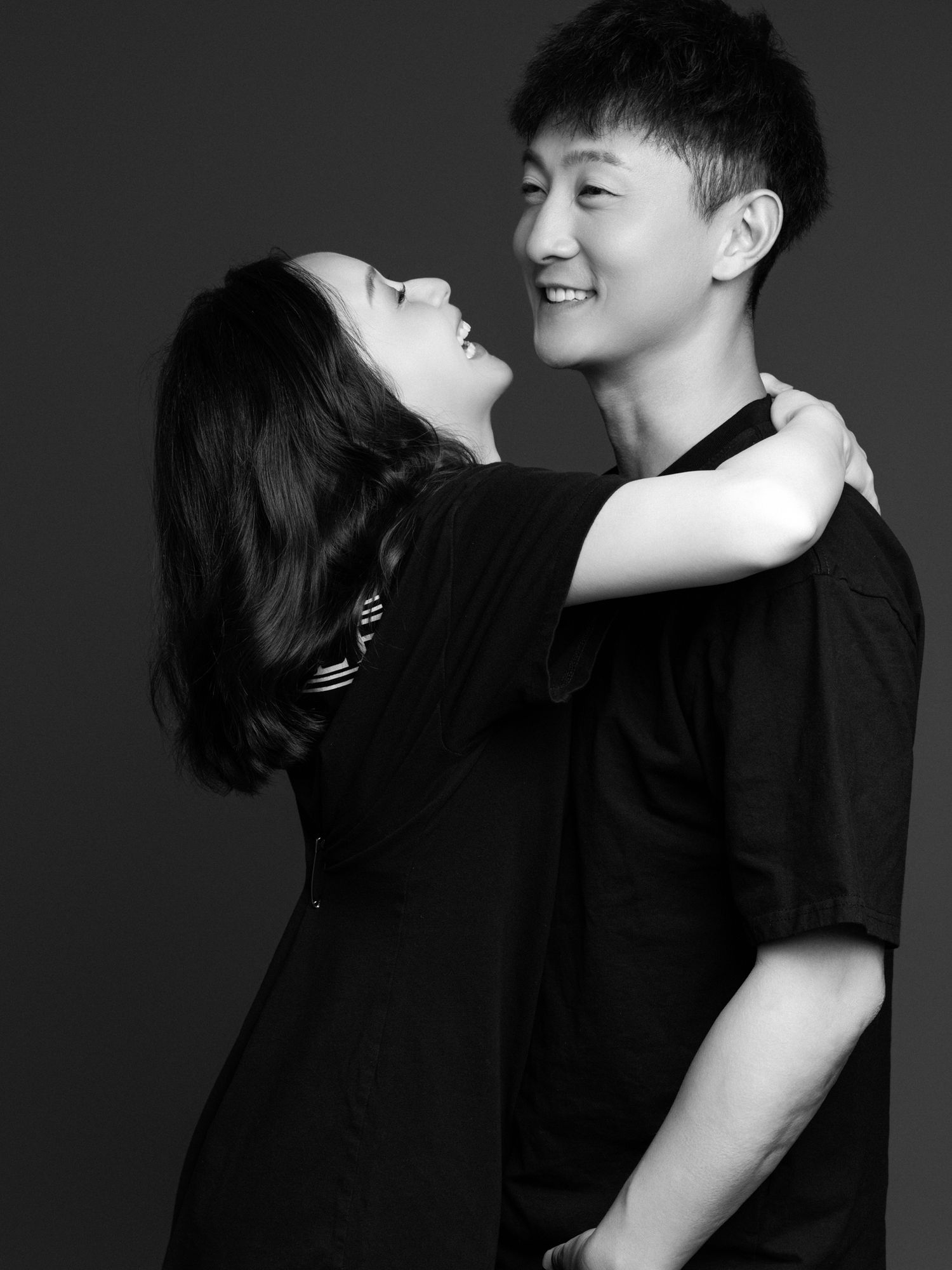 Studio portraits showing playful interaction between couple in black attire.