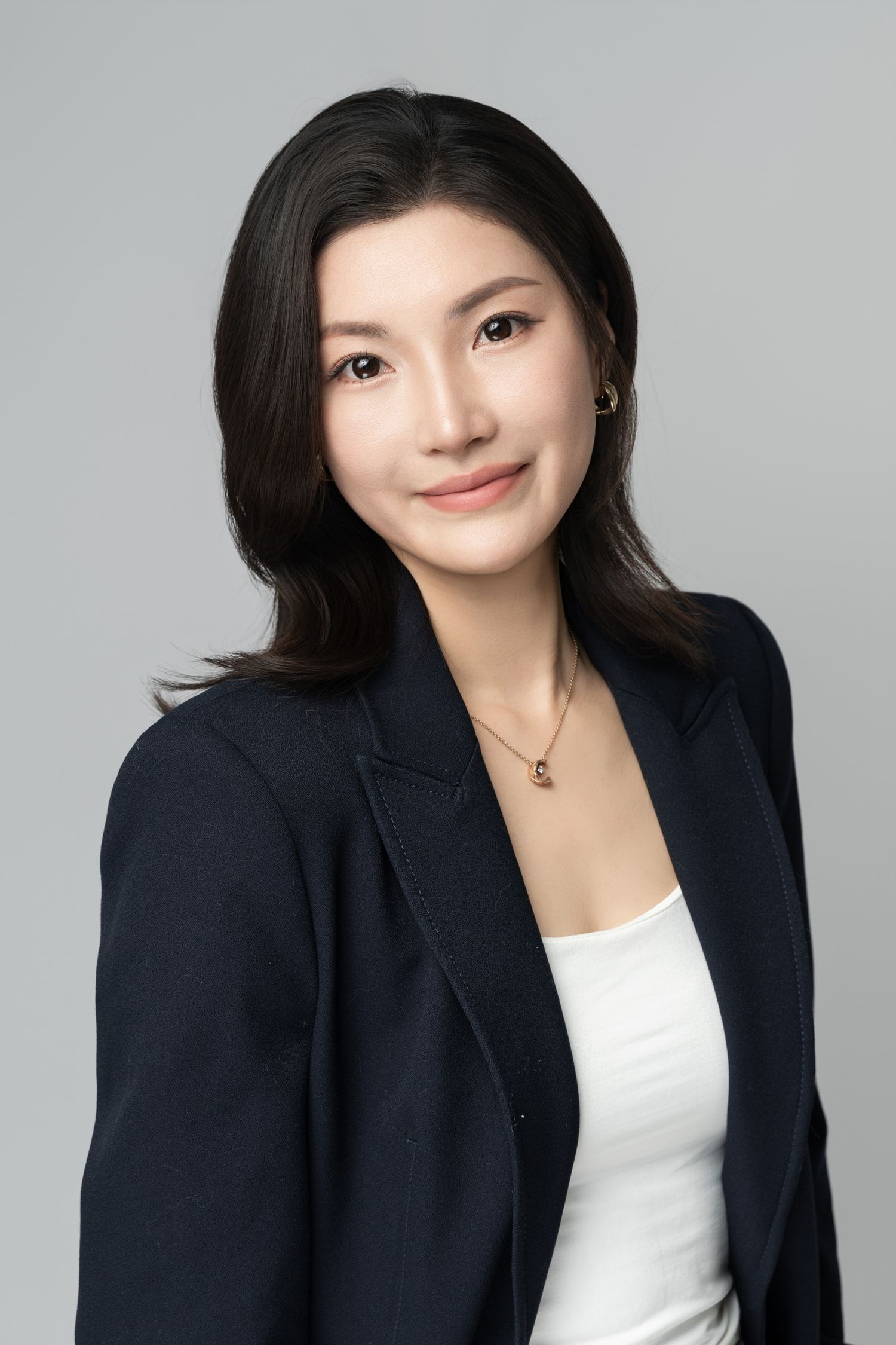 Studio portrait series showing person in navy blazer with white top against light background.