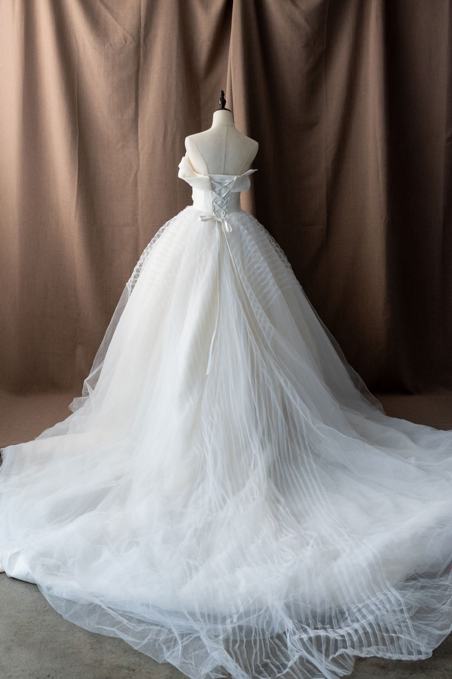 Dramatic ball gown wedding dress with cathedral train shown from back view.
