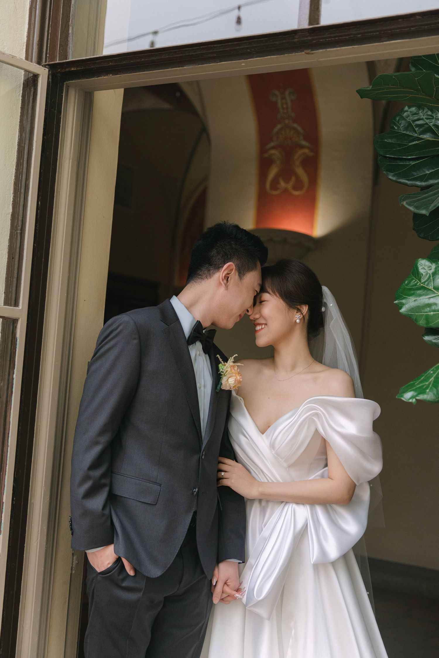 A couple shares a romantic moment in an elegant doorway setting.