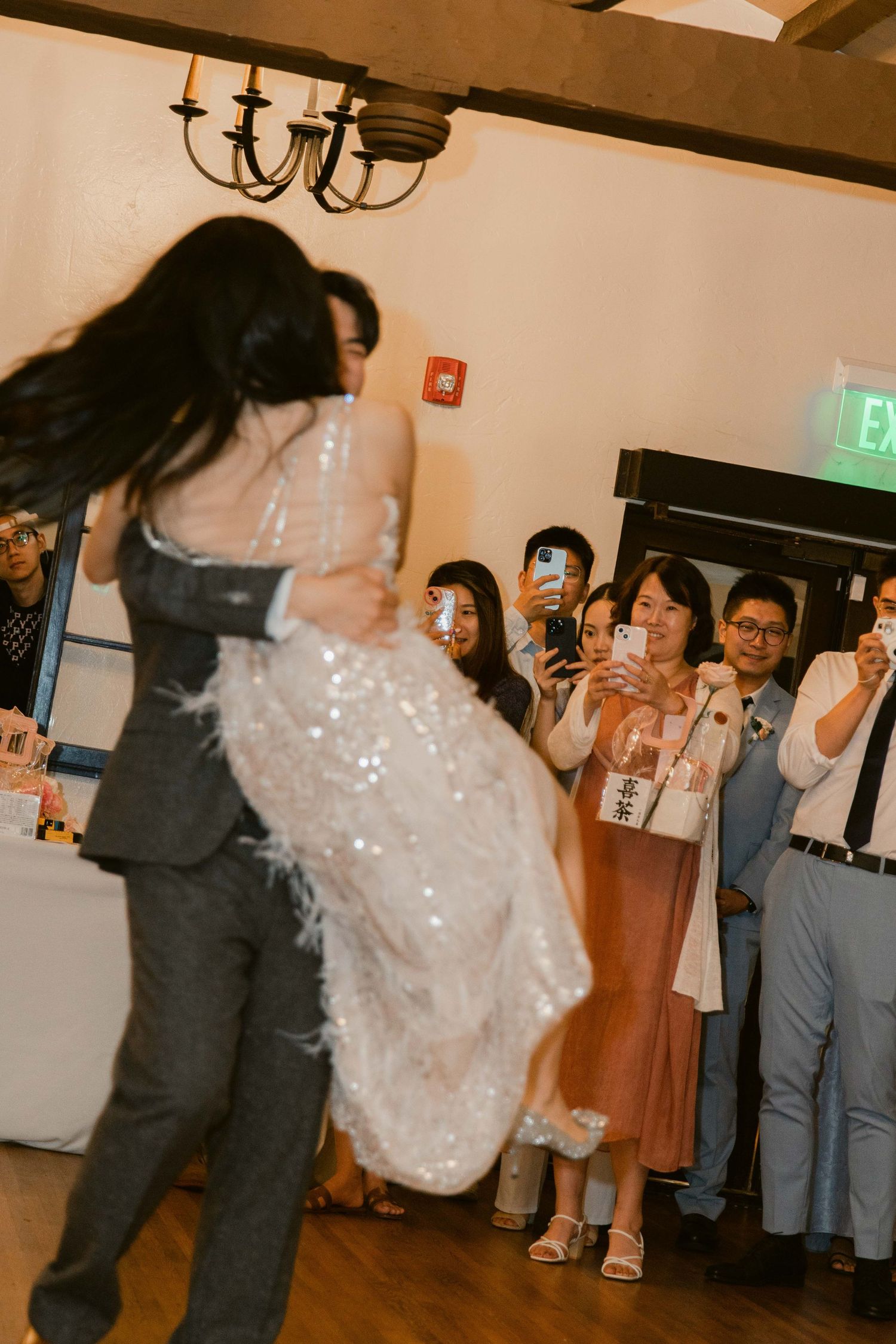 Wedding reception dance floor with guests celebrating in formal attire.
