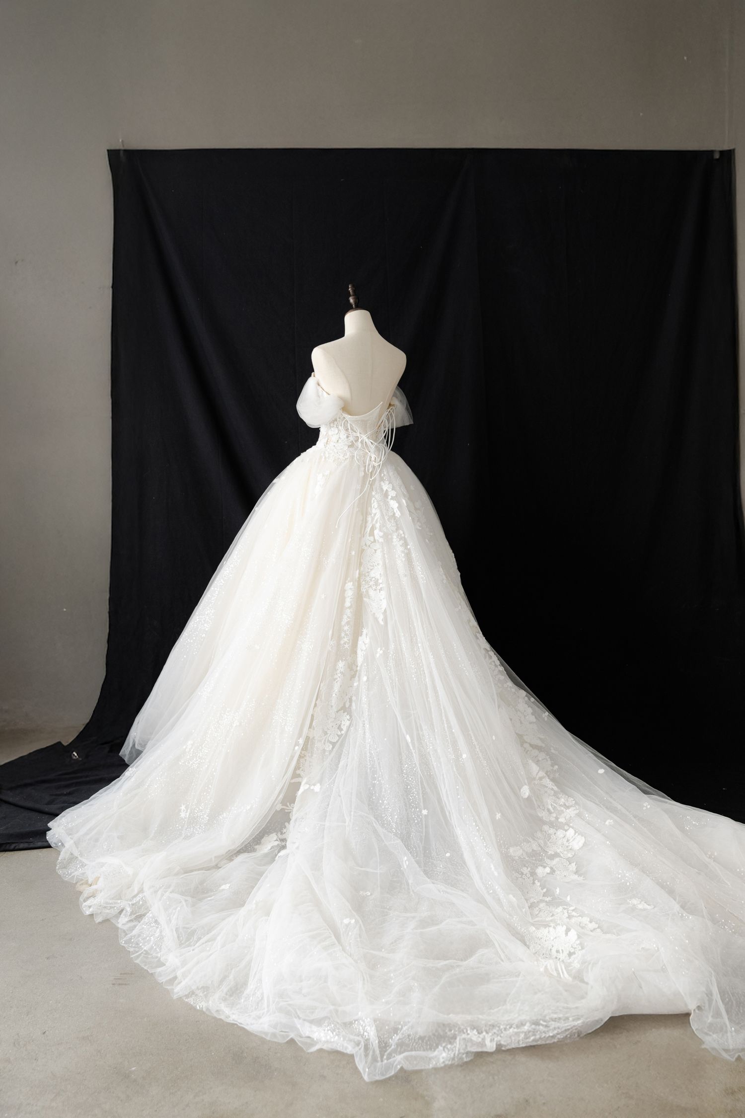 Dramatic ballgown wedding dress with flowing tulle skirt and long train on display.