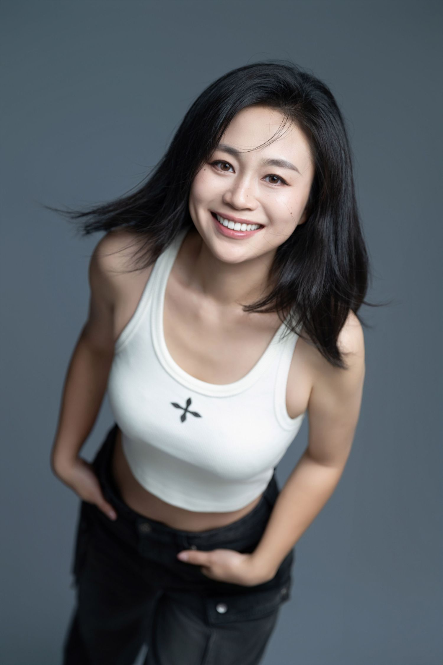 Energetic studio shot showing movement and joy in casual attire.