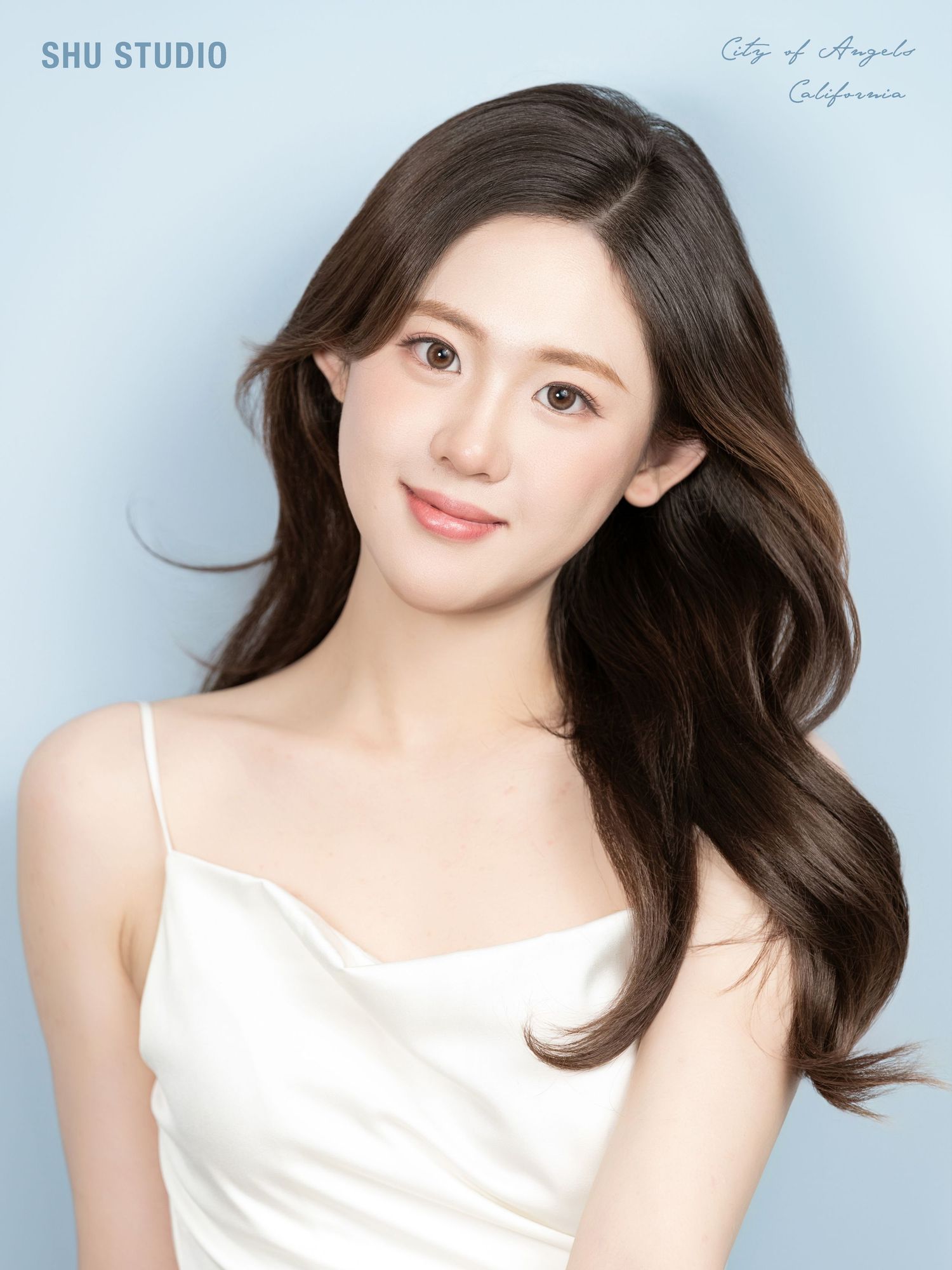 Studio portrait series in white silk camisole against soft blue background.