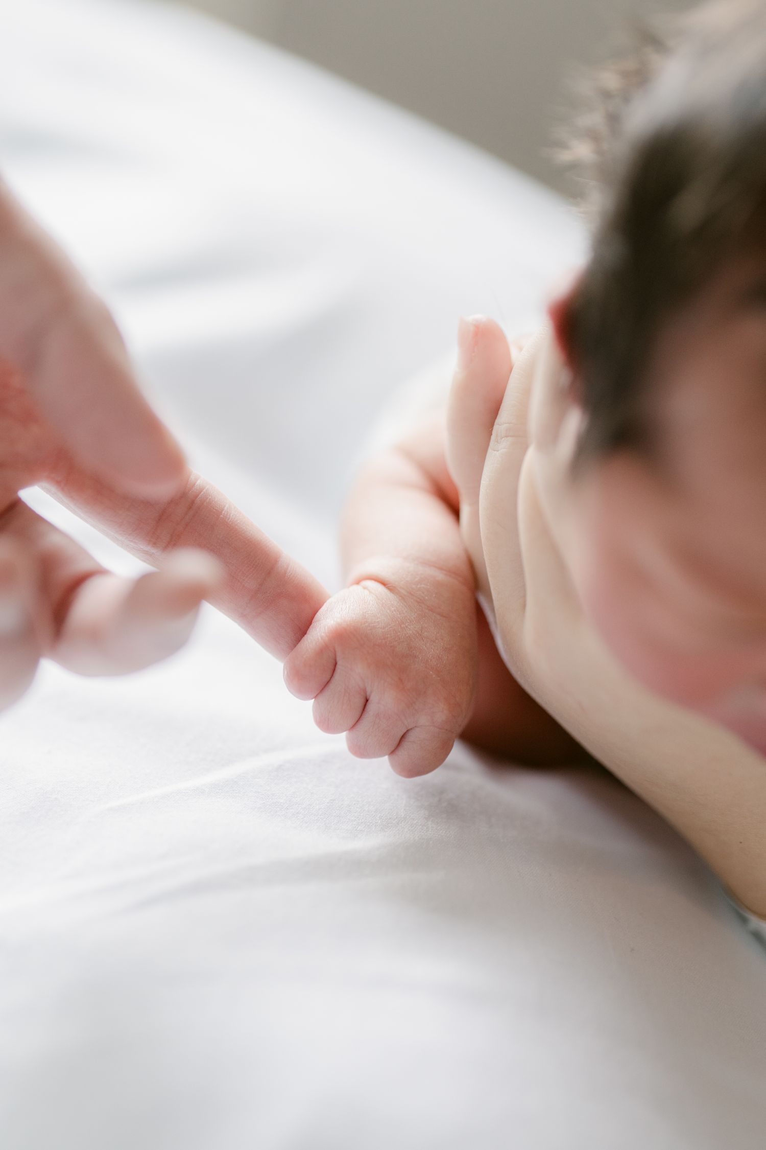 Close-up detail of baby's tiny feet against white bedding.