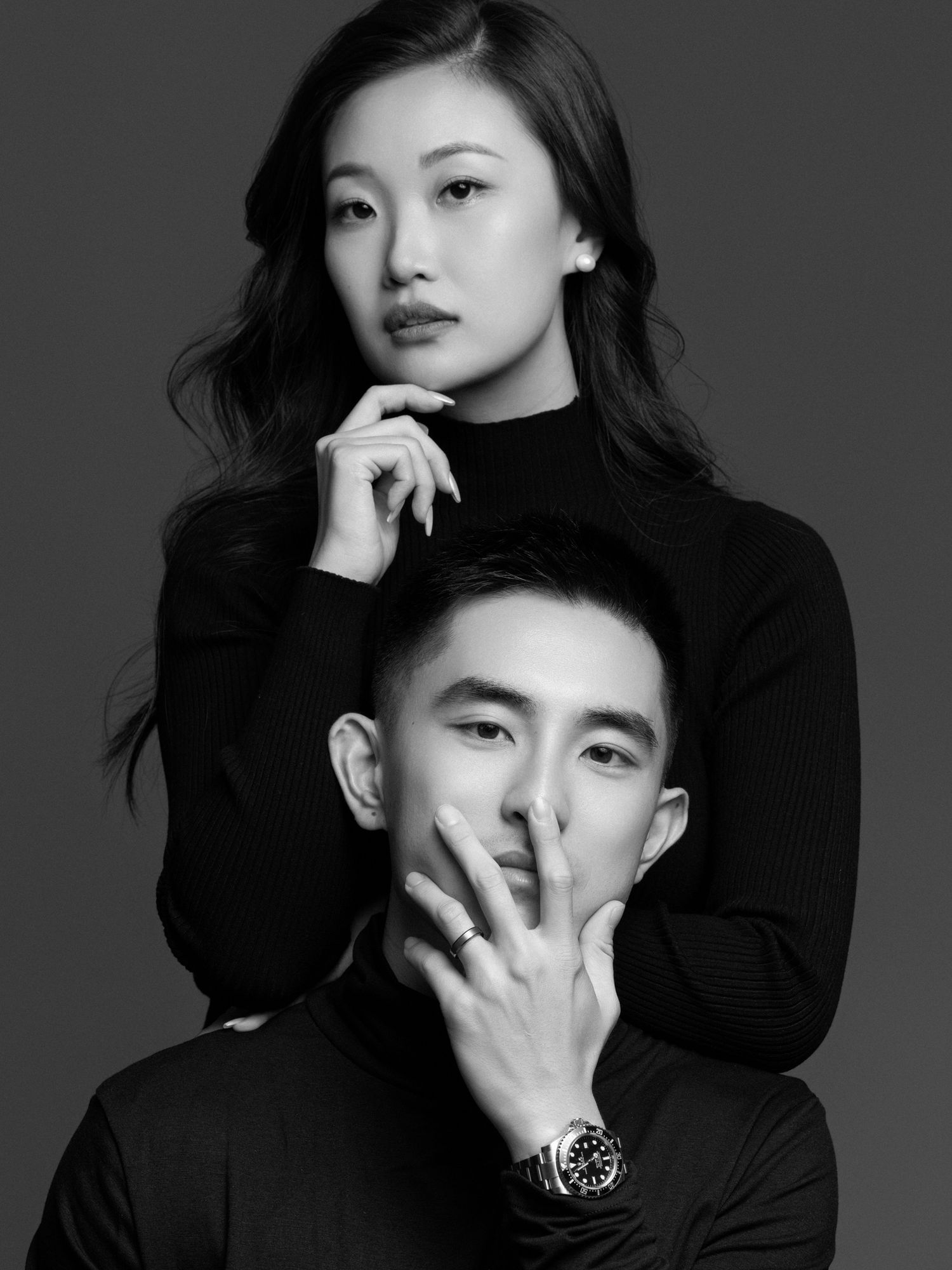 Black and white portrait series showing playful poses against dark background.