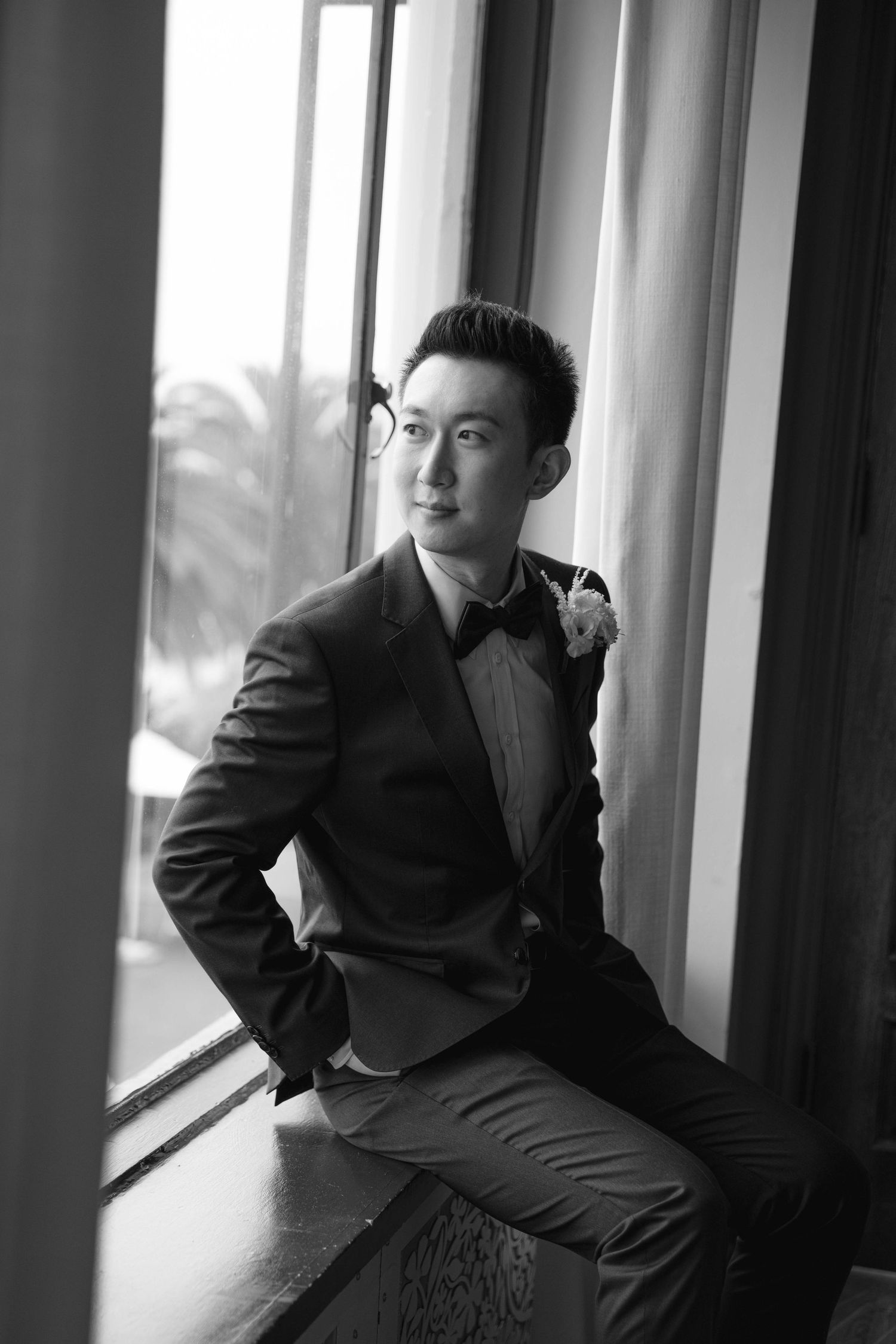 Black and white wedding photos showing artistic poses near windows with natural light.