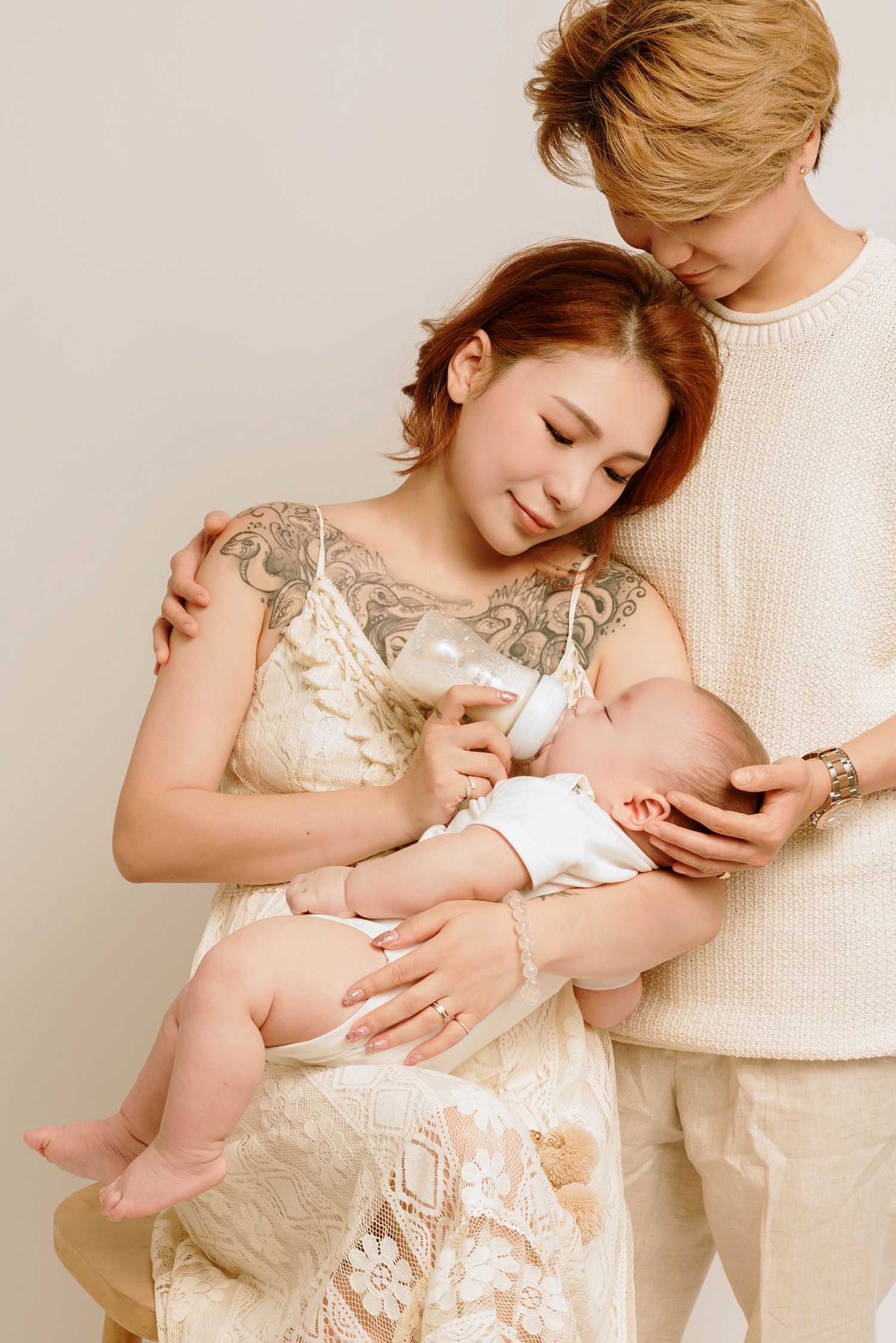Intimate family portrait in cream tones with lace dress and knit sweater.