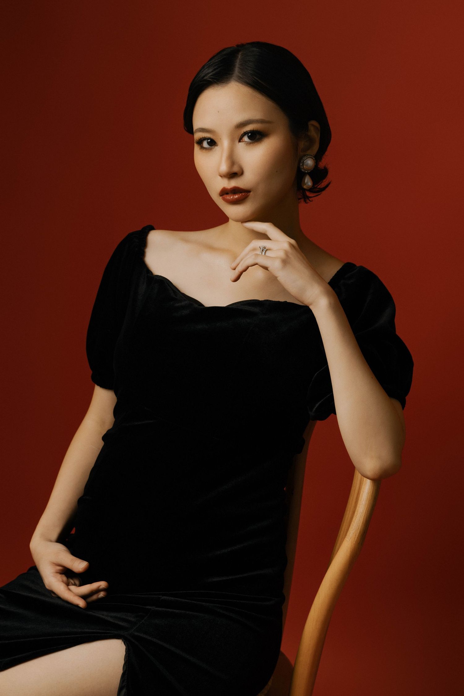 Artistic portrait series against deep red background featuring elegant poses in black attire.