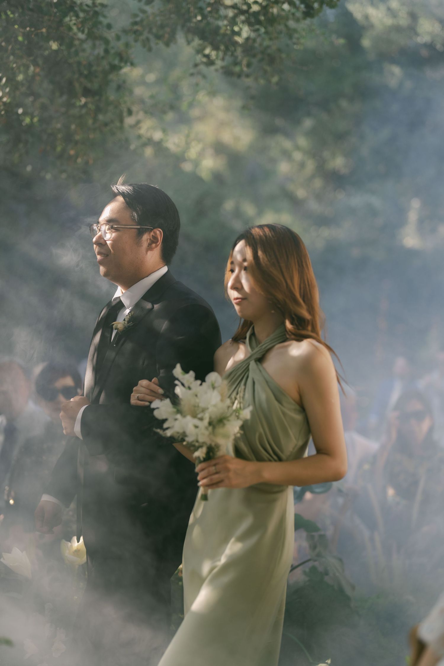 Couple laughing together during outdoor wedding celebration with smoke effects.