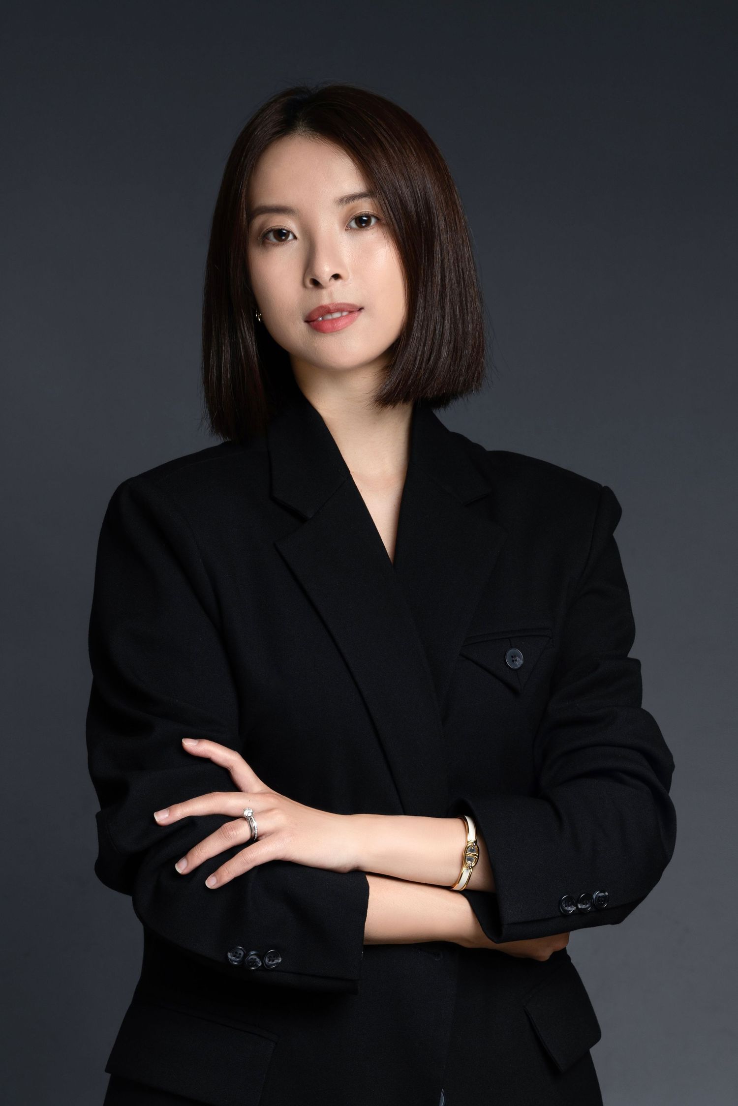 Professional studio portrait series featuring person in black blazer against dark background.