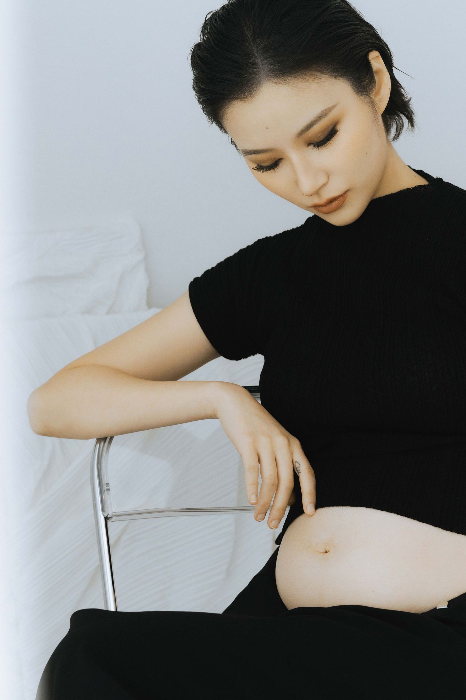 Close-up sequence showing gentle movements in black clothing against white backdrop.