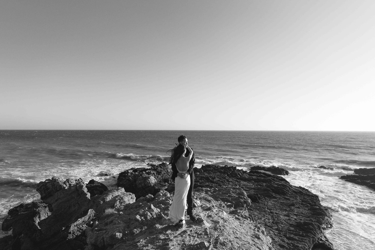 Dramatic black and white coastal landscape with rocky cliffs overlooking the ocean.