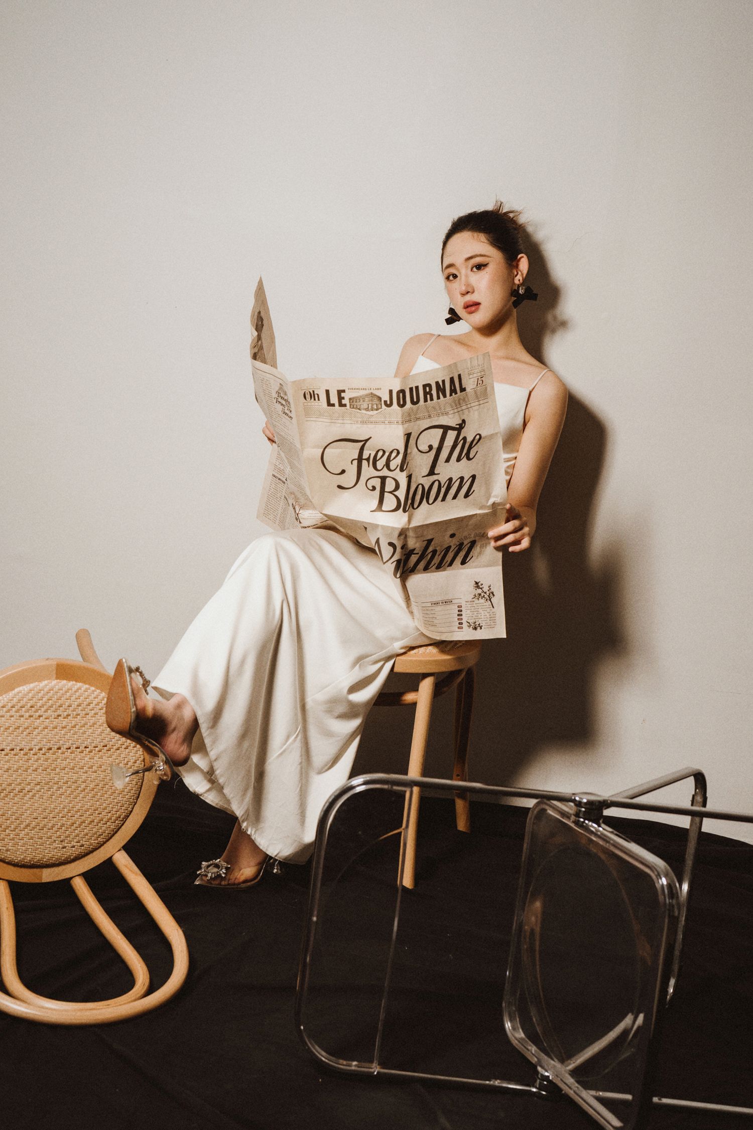 Stylish vintage-inspired photoshoot with newspaper and rocking chair props.