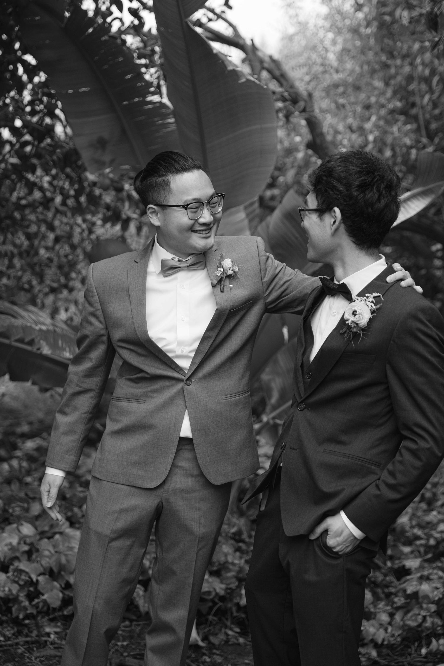 Groomsmen in suits share a candid laughing moment together during wedding photos.