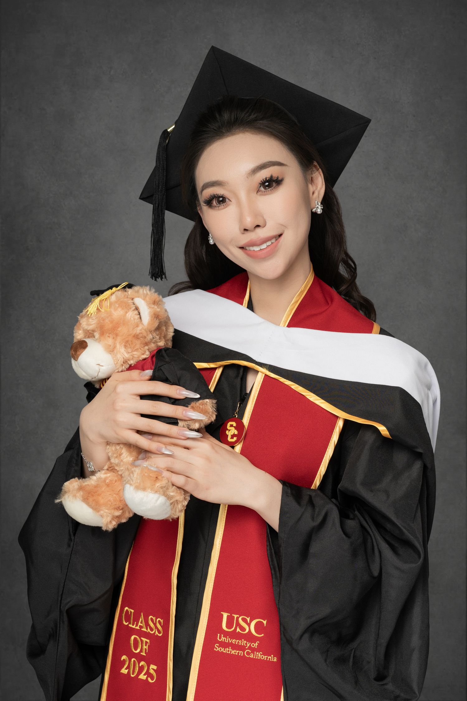 Graduation photos in USC cap and gown holding teddy bear against dark background.