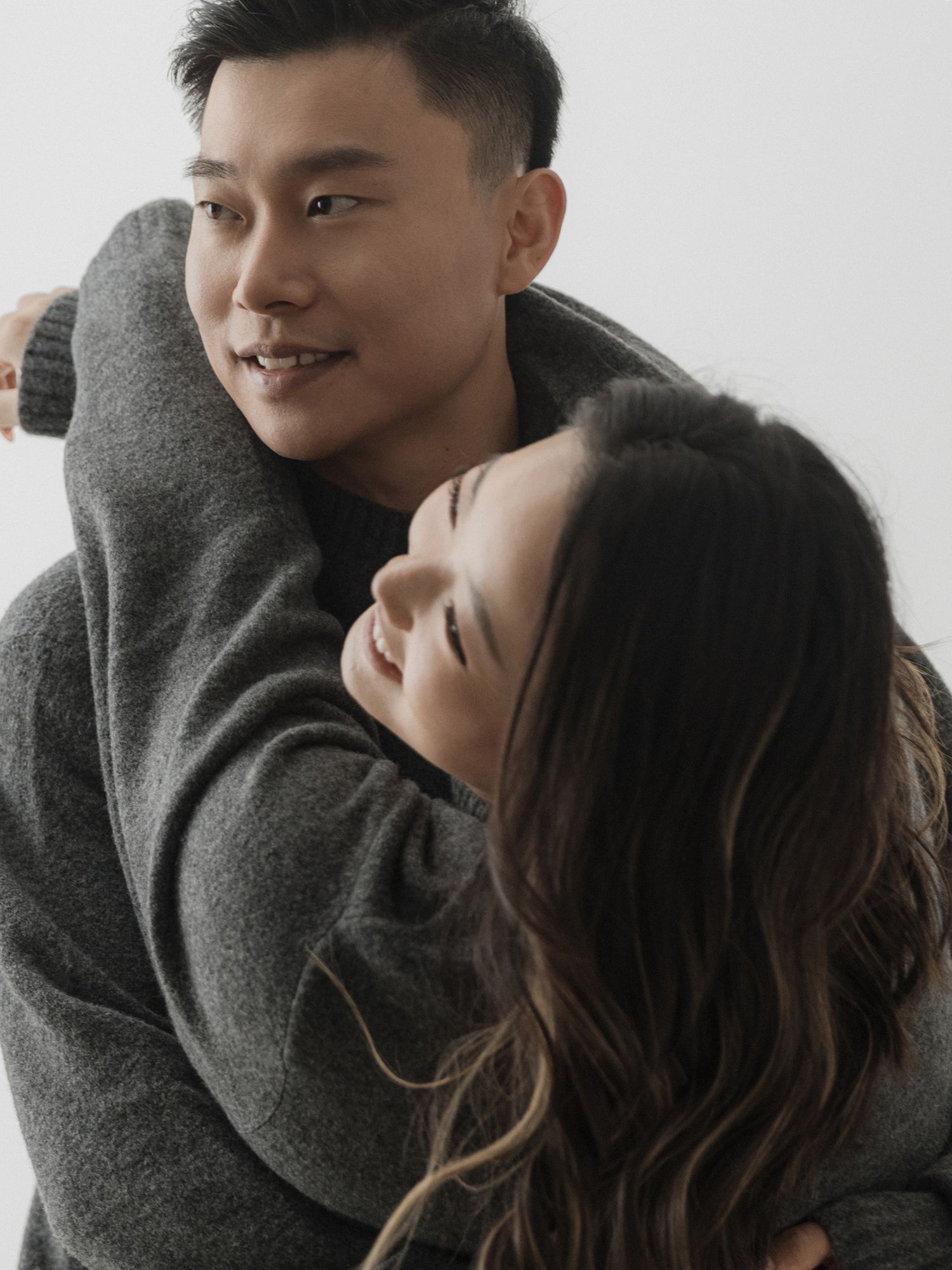 Intimate couple in gray sweaters sharing tender moments in a romantic photoshoot sequence.