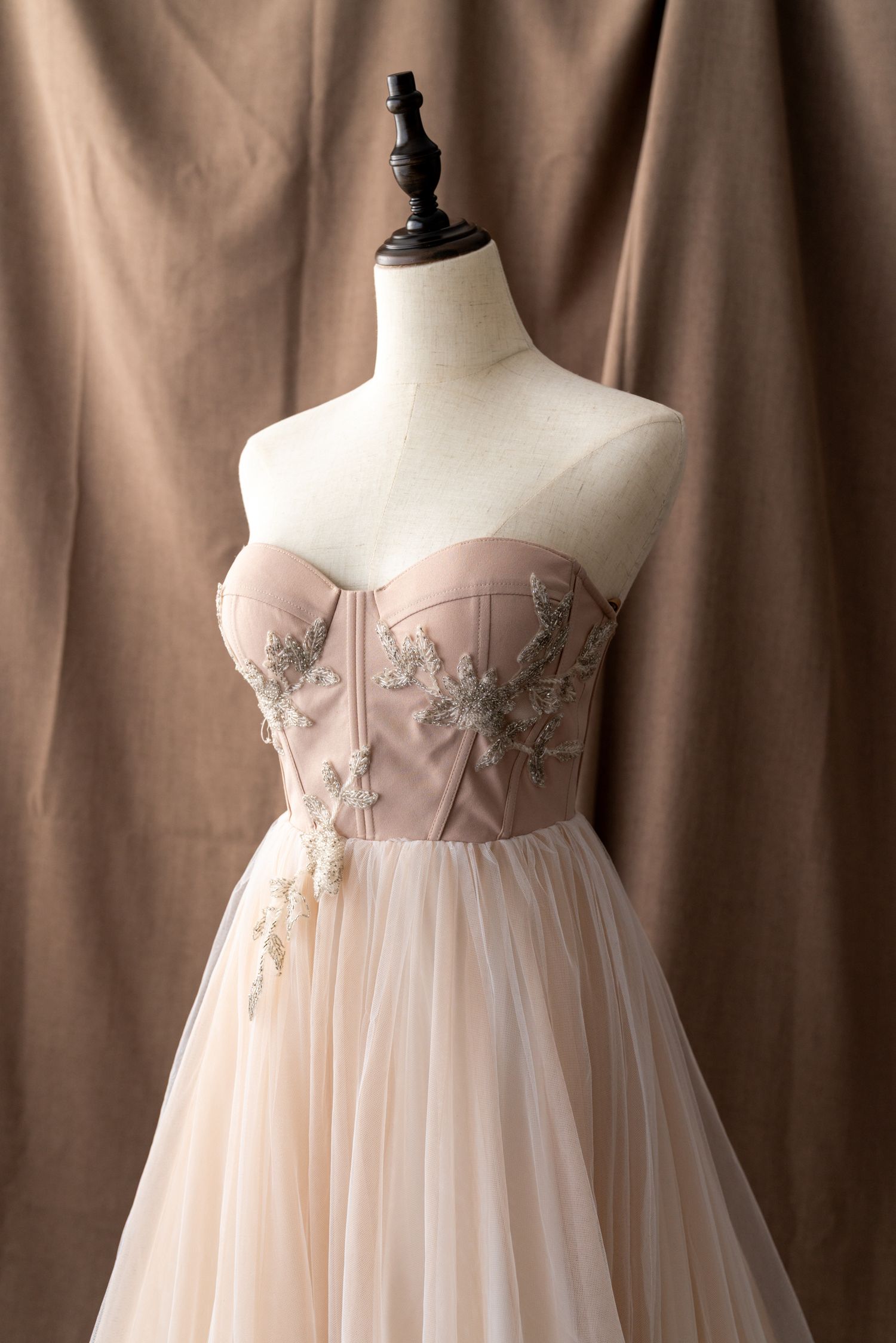 Strapless blush wedding gown with embellished bodice and flowing tulle skirt.