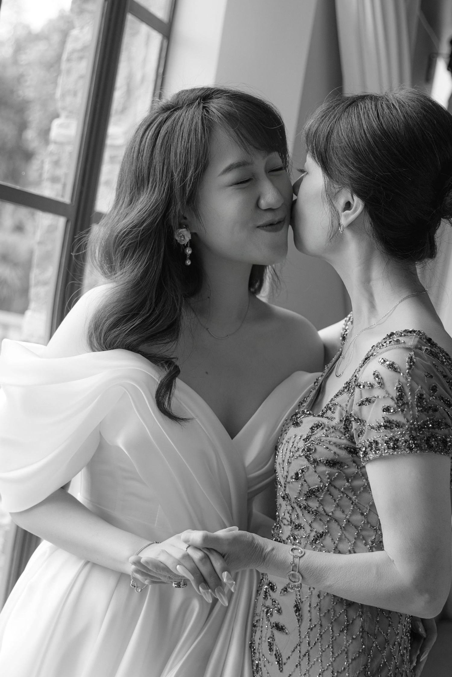 Black and white candid moments between two people during wedding preparations.