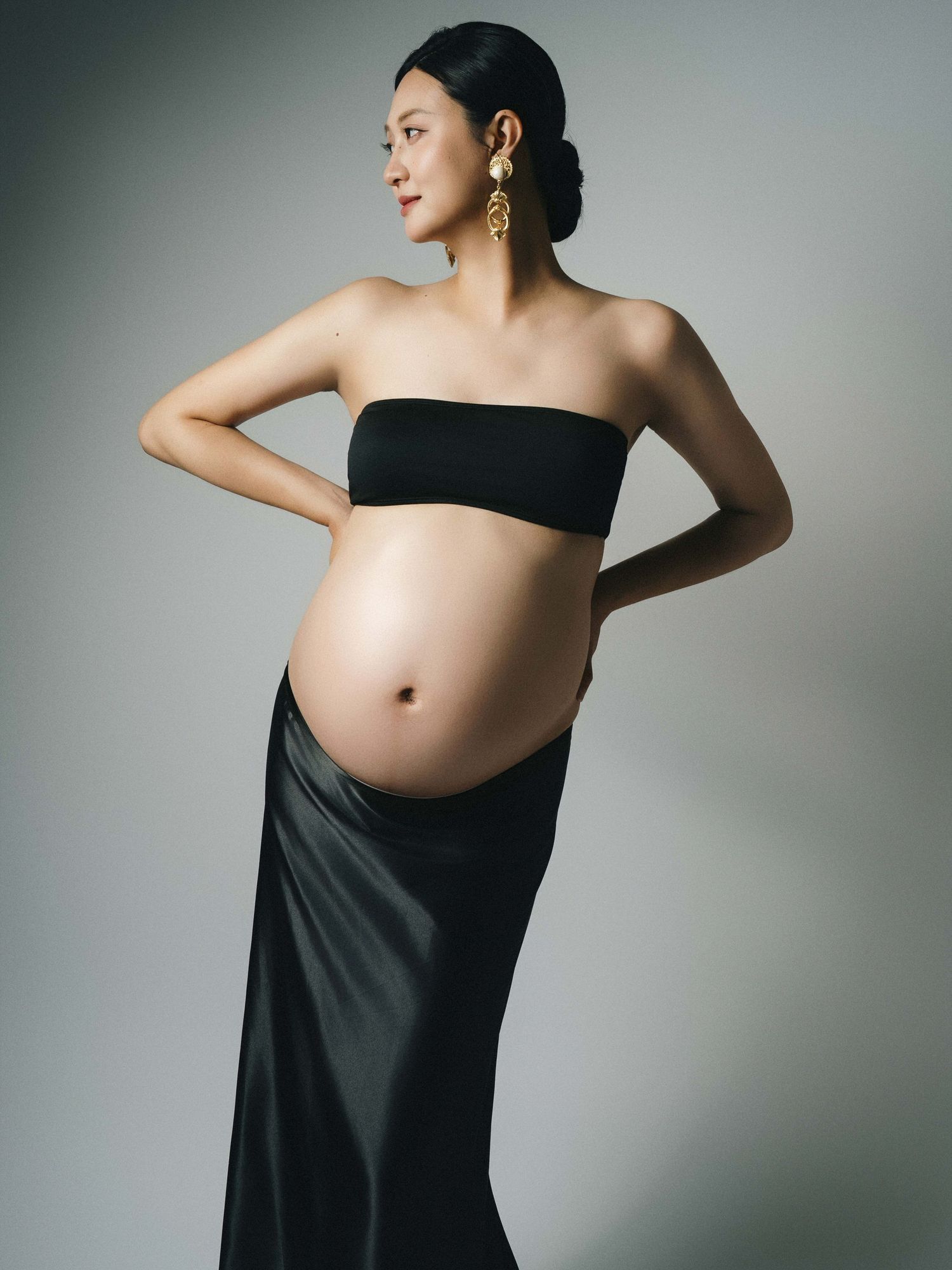 Artistic black and white maternity portrait with draped fabric.