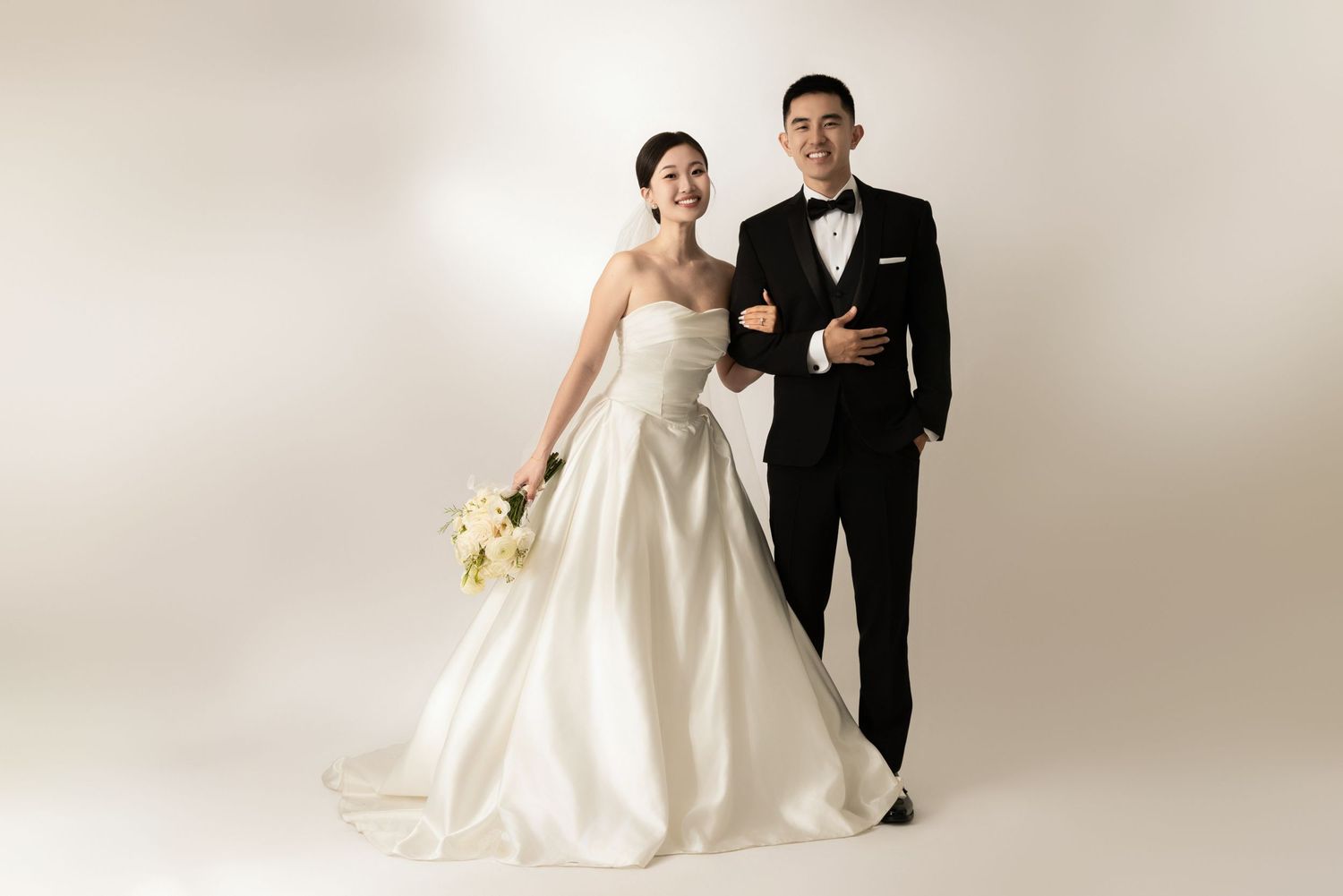 Elegant wedding portraits against white backdrop showing couple in formal attire.