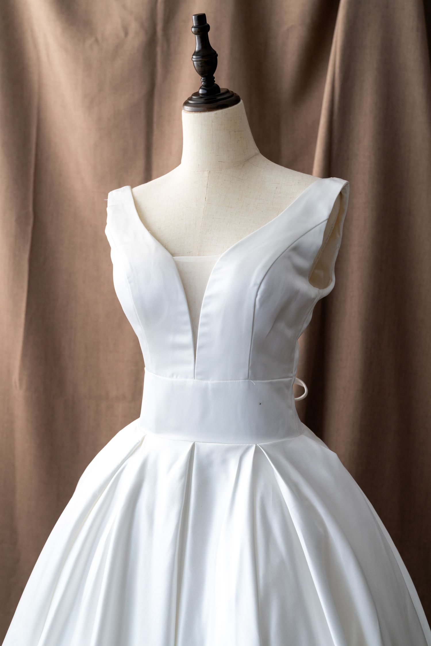 White strapless wedding dress with sweetheart neckline and structured bodice displayed on a mannequin.