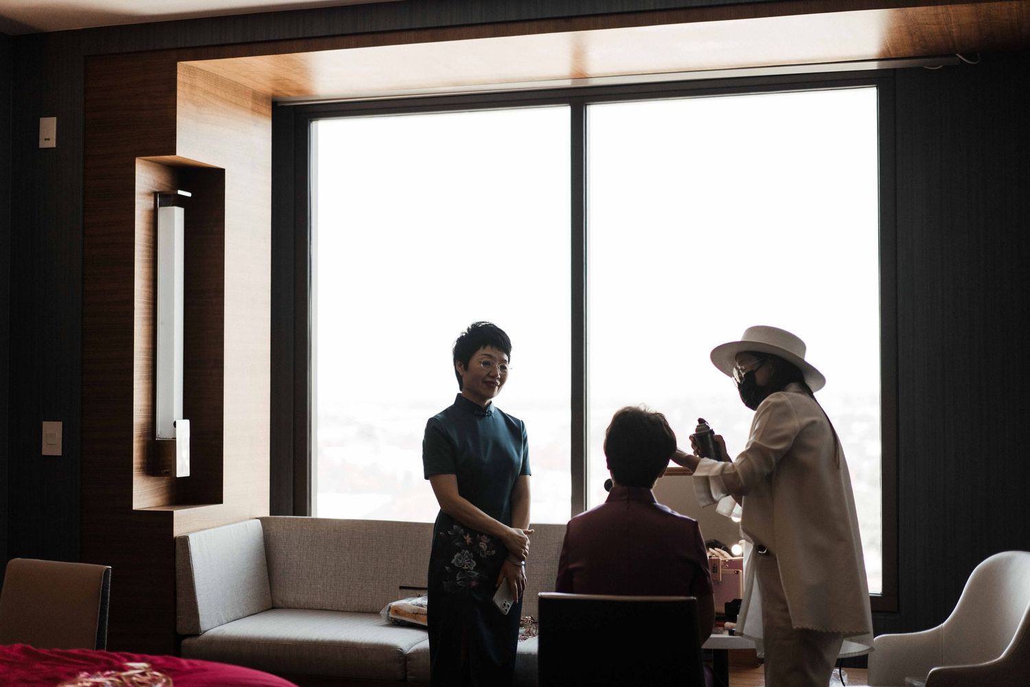 Silhouettes of people against bright windows in a modern interior space.