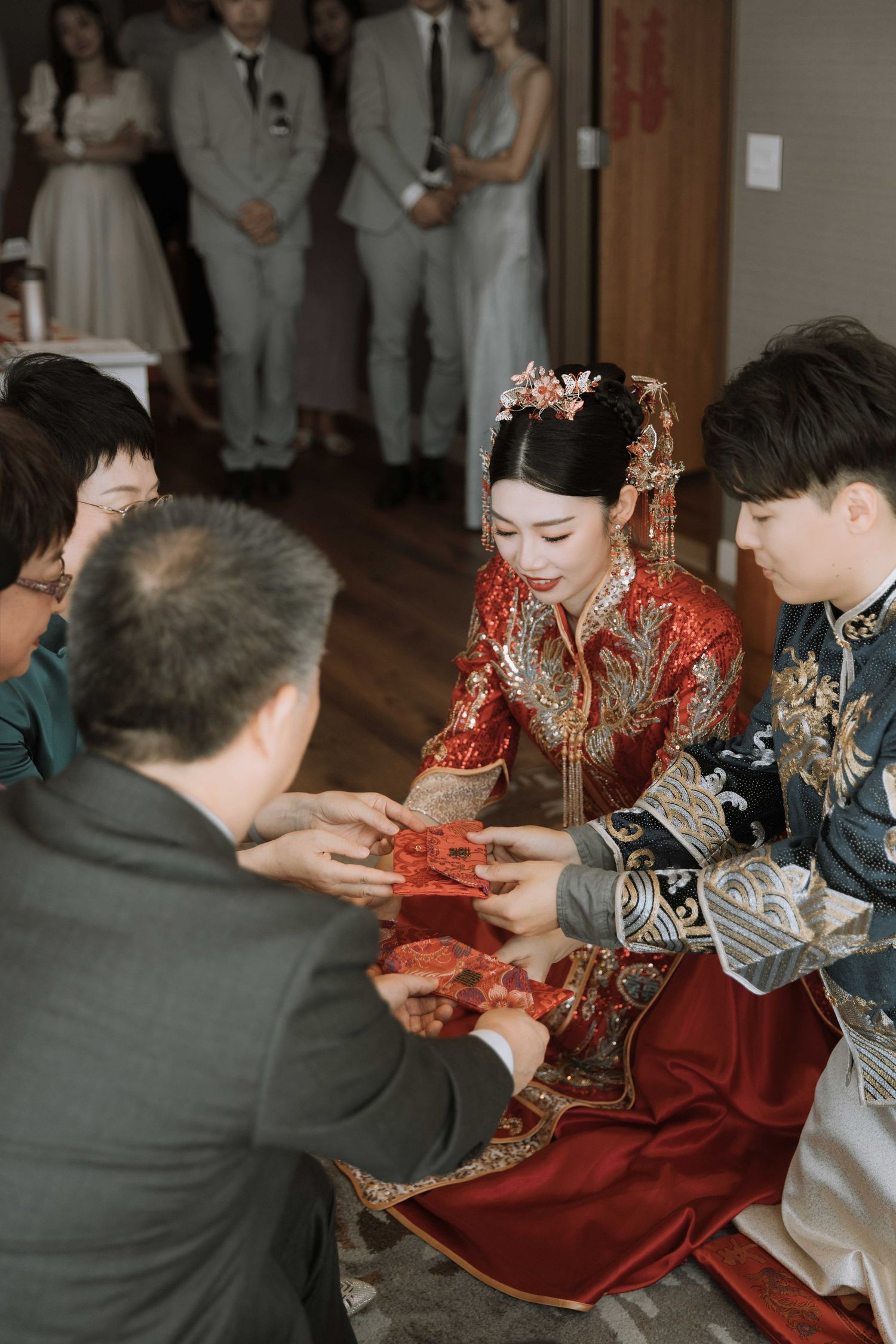 Wedding ceremony showing traditional Chinese tea ceremony with guests in formal attire.