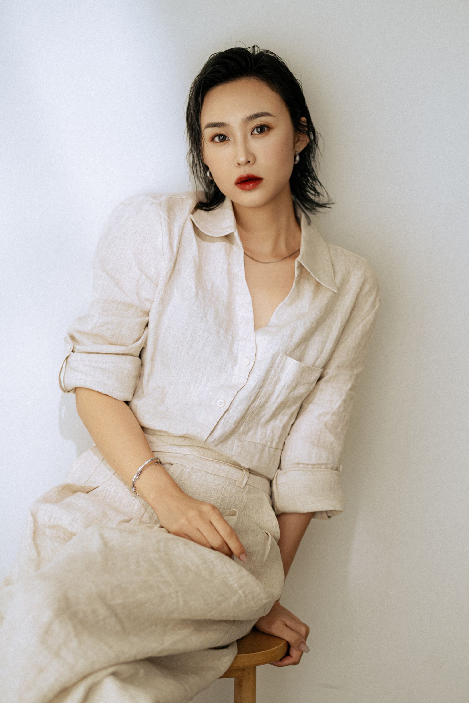 Editorial style portraits in cream linen outfit against minimalist white background.