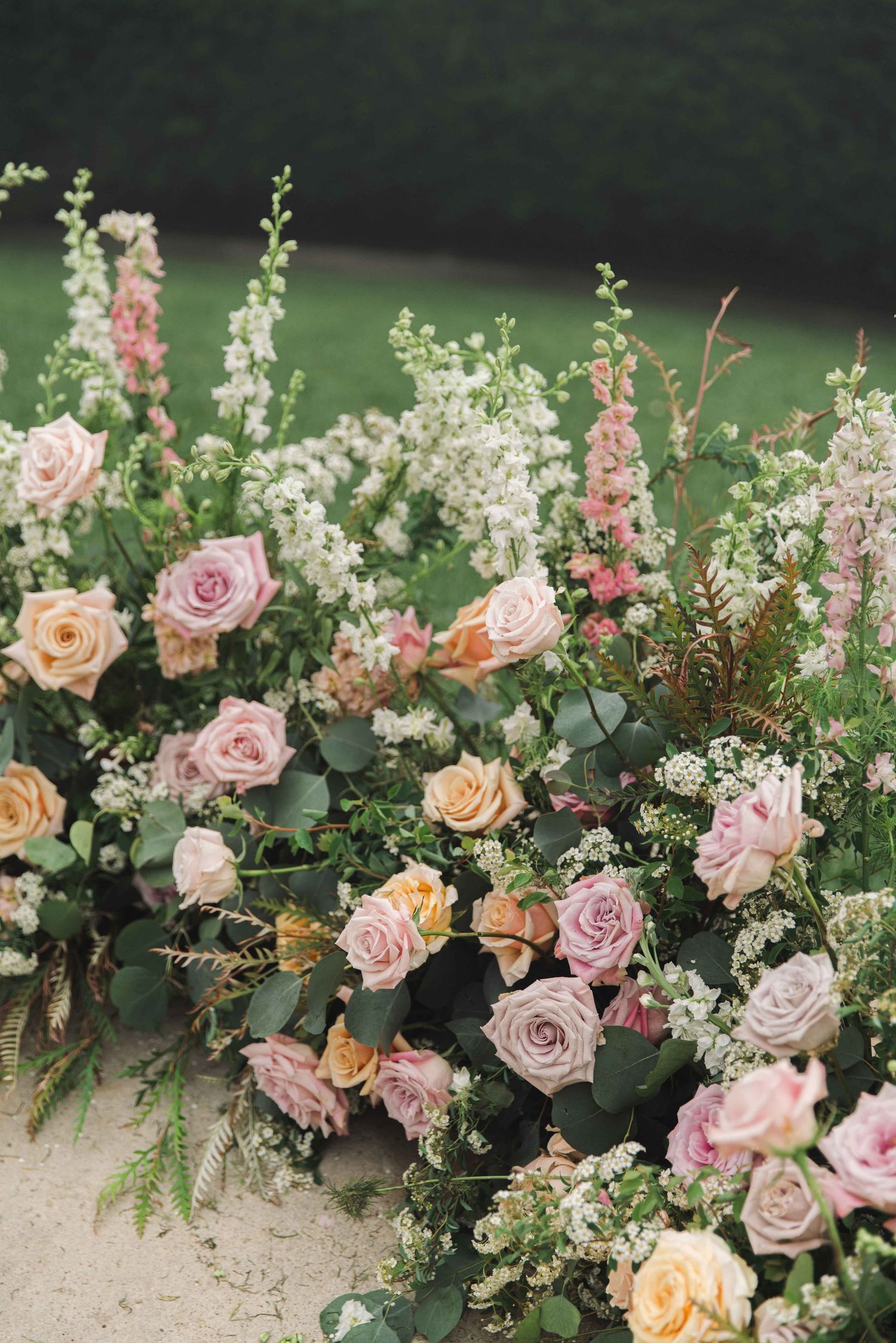 Beautiful floral arrangement featuring pink and peach roses with delicate greenery.