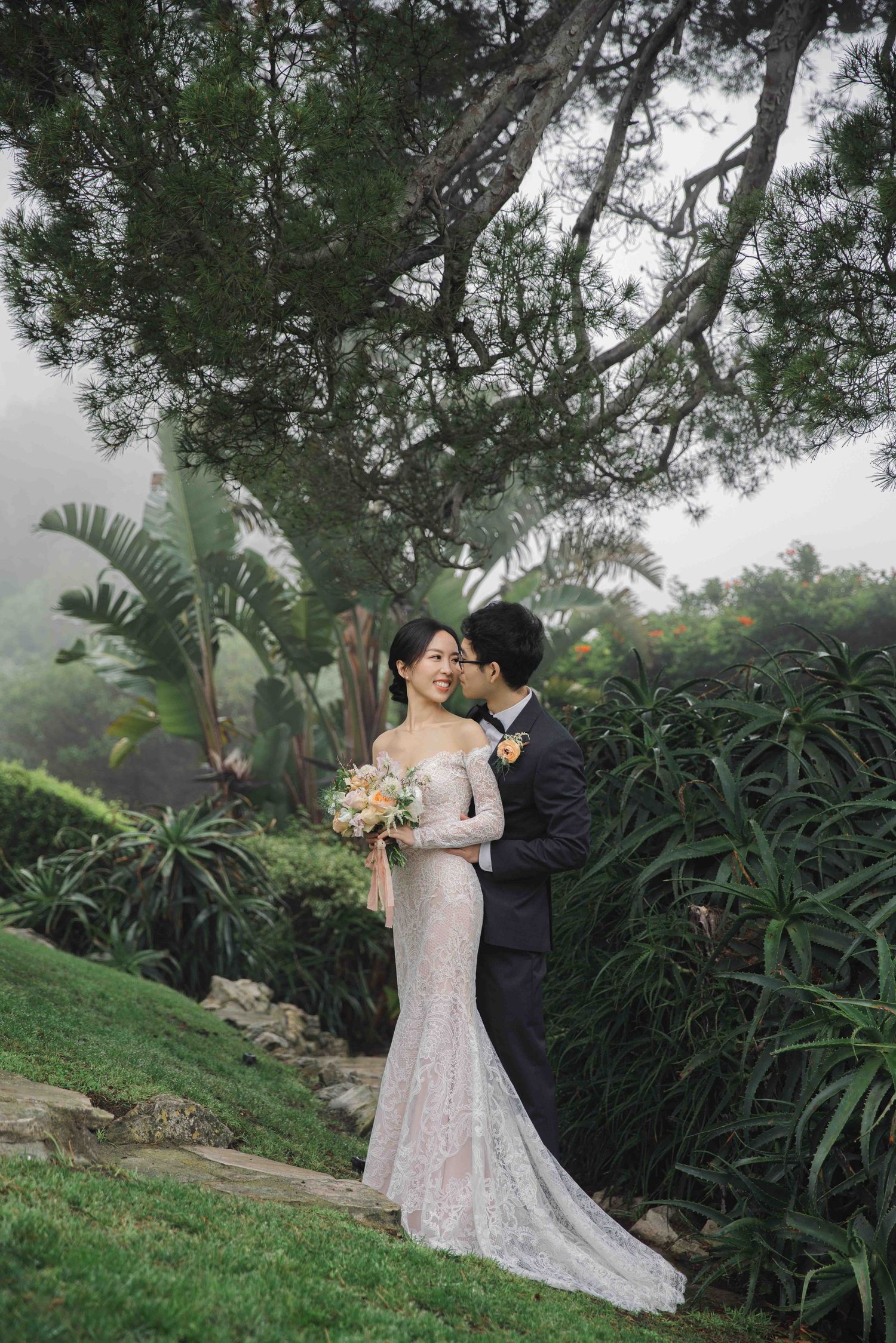 Garden wedding photos with a couple surrounded by tropical plants and greenery.