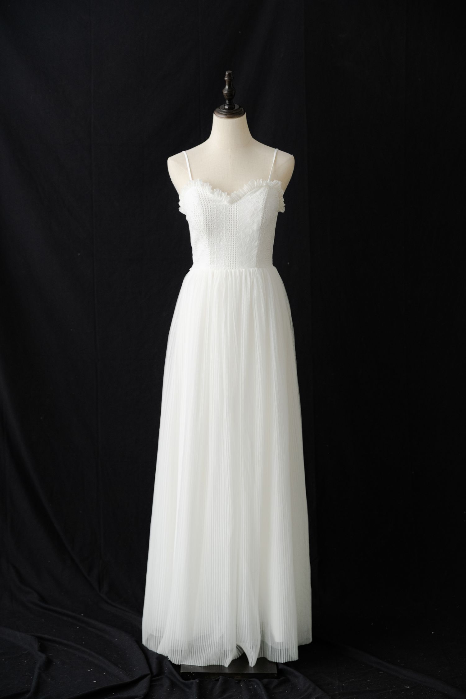 Flowy white empire waist dress with spaghetti straps shown on dress form.