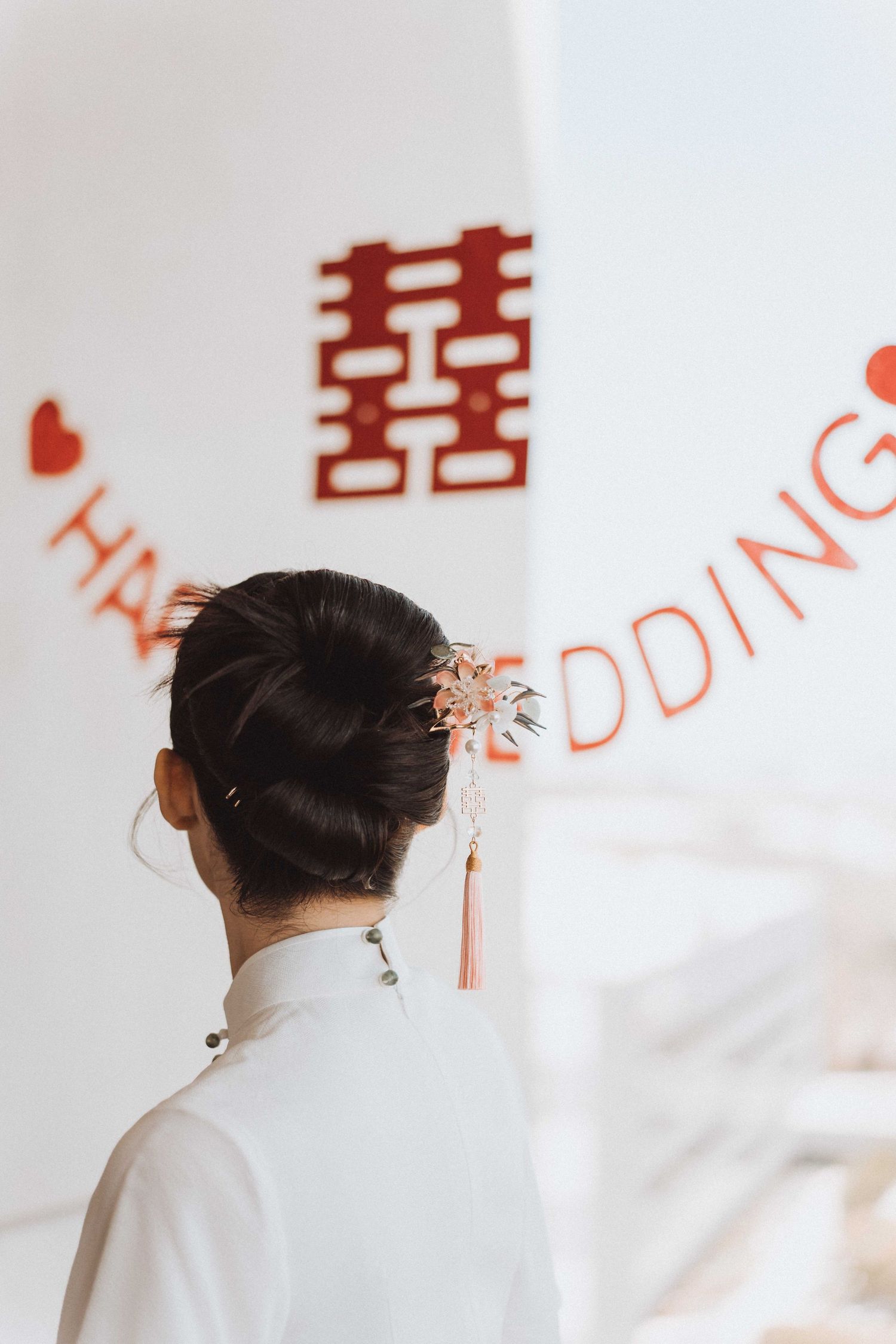 Traditional Chinese wedding decor with red double happiness characters on white wall.