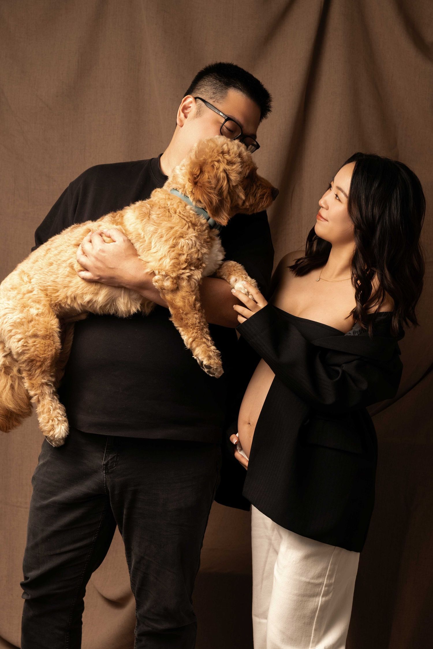 Couple poses lovingly with a fluffy teddy bear in a series of intimate black and white photos.
