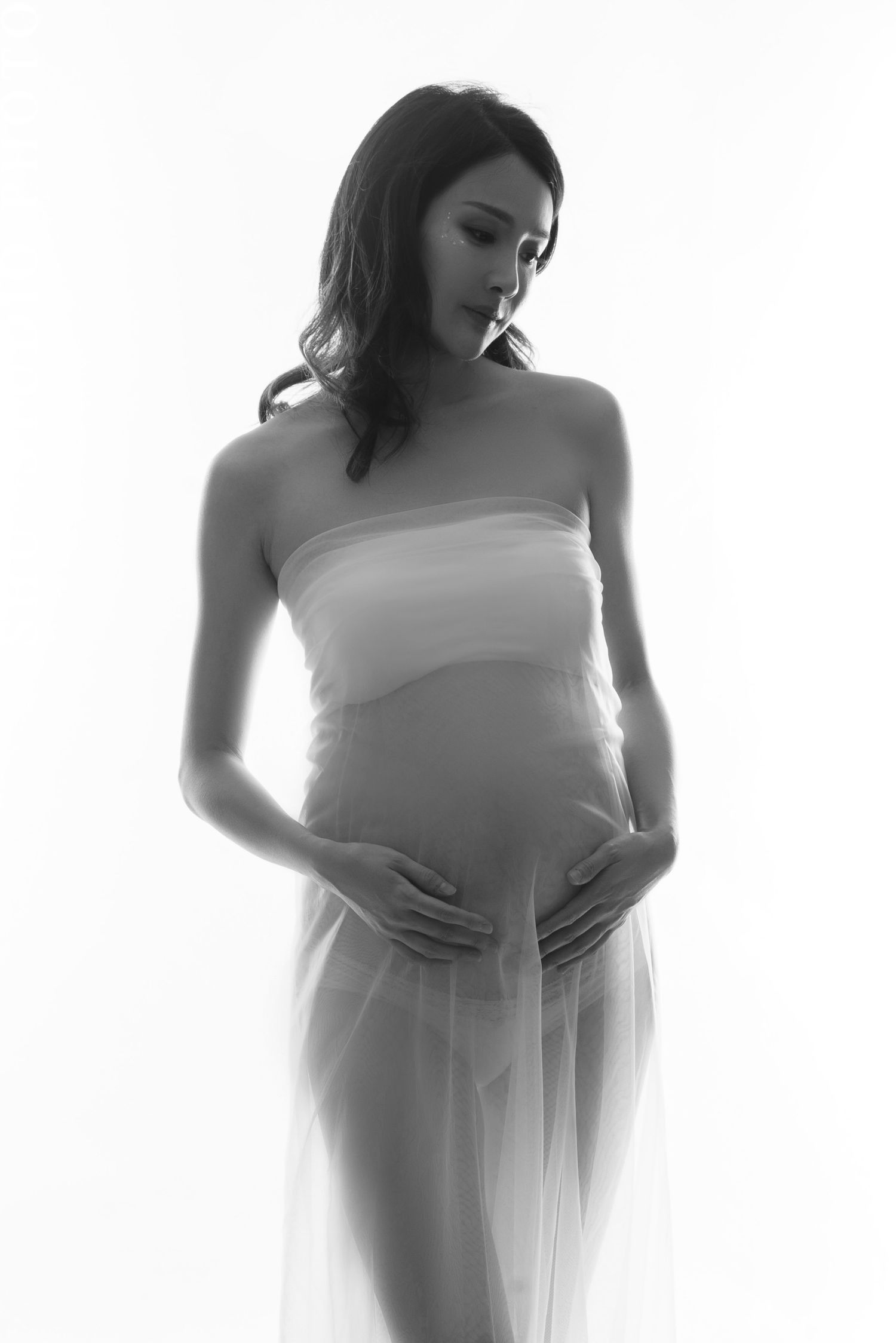 Minimalist black and white maternity silhouette series with draped fabric.