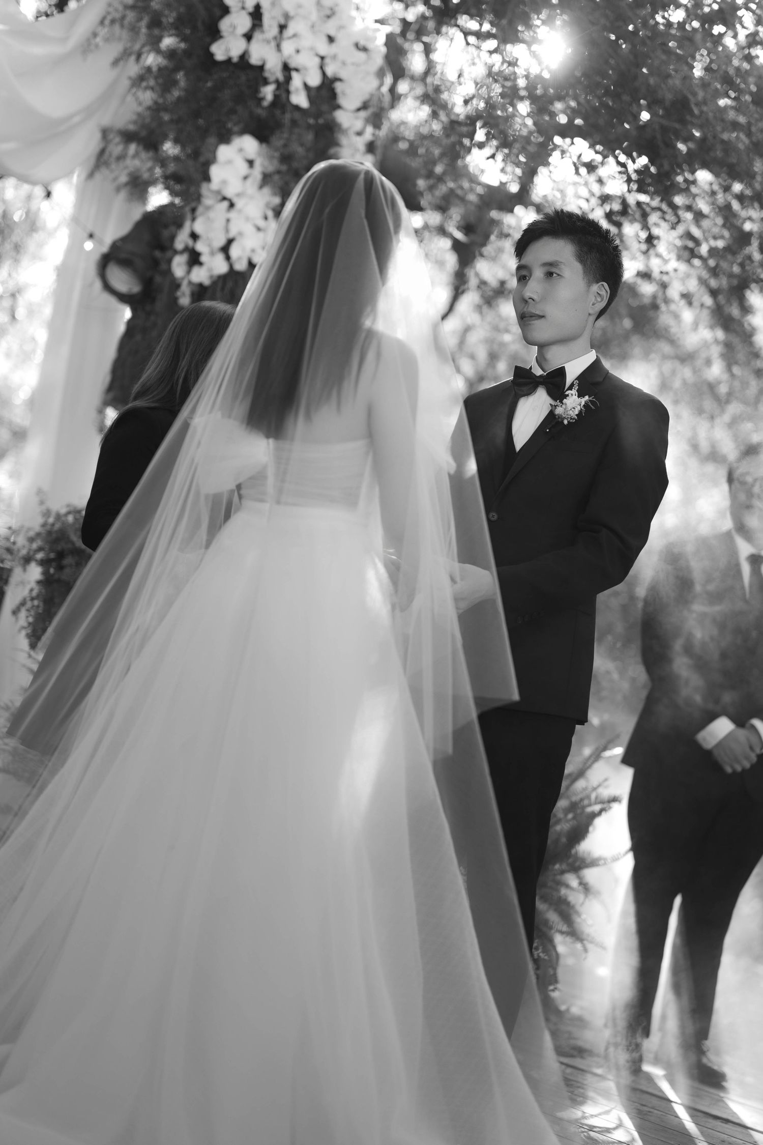 Ethereal black and white wedding scene with flowing bridal veil.