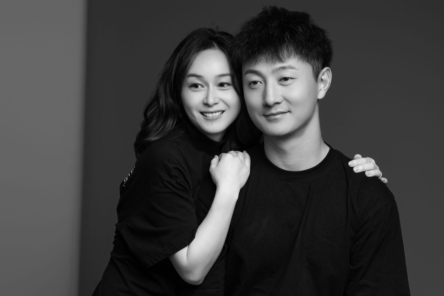 Professional studio portraits of couple showing genuine connection in black and white.