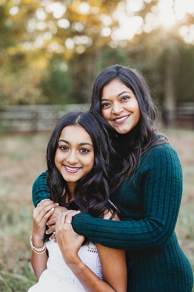 Two women smiling and embracing warmly during an outdoor fall photo session Richmond VA family photography. Midlothian, Petersburg, Glen All
