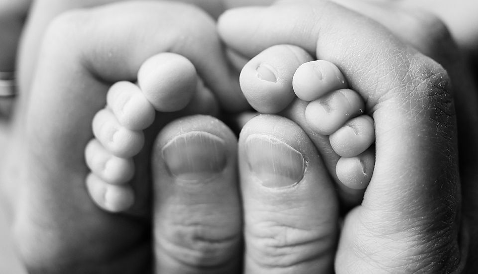 Black and white close-up of newborn baby feet in parent hands newborn photographer Richmond Chesterfield midlothian Petersburg