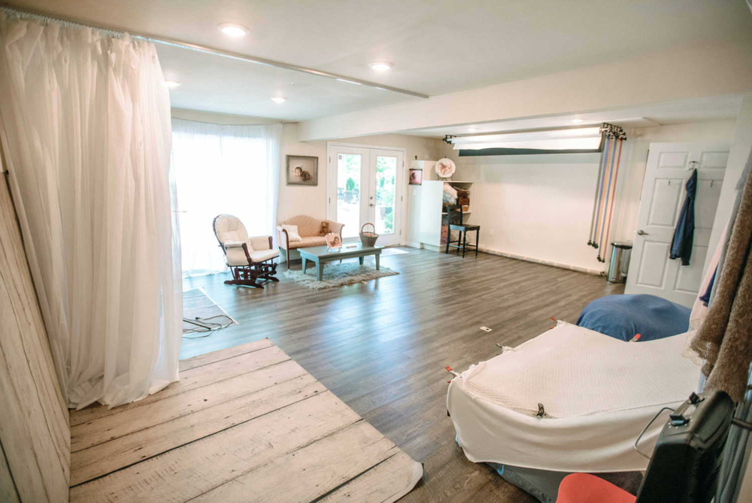 Spacious open-plan living area with hardwood floors, white curtains, vintage furniture, and bright natural light. studio in Chesterfield