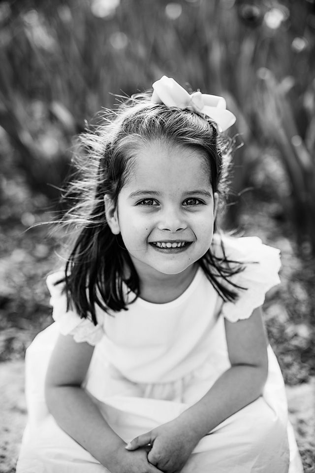 Smiling brunette girl with bow in black and white portrait. short pump family photographer