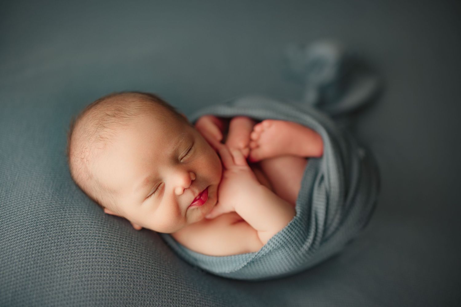 Peaceful newborn baby sleeping wrapped in a soft teal blanket with tiny feet visible Richmond newborn photographer, baby, Chesterfield