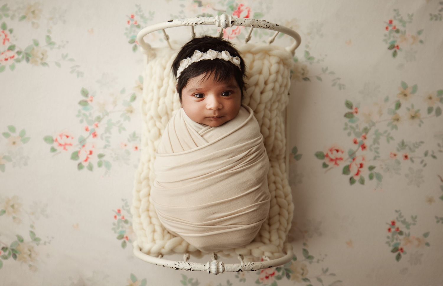 Newborn baby wrapped in cream swaddle with floral headband in vintage white newborn photographer Richmond Chesterfield midlothian Peters