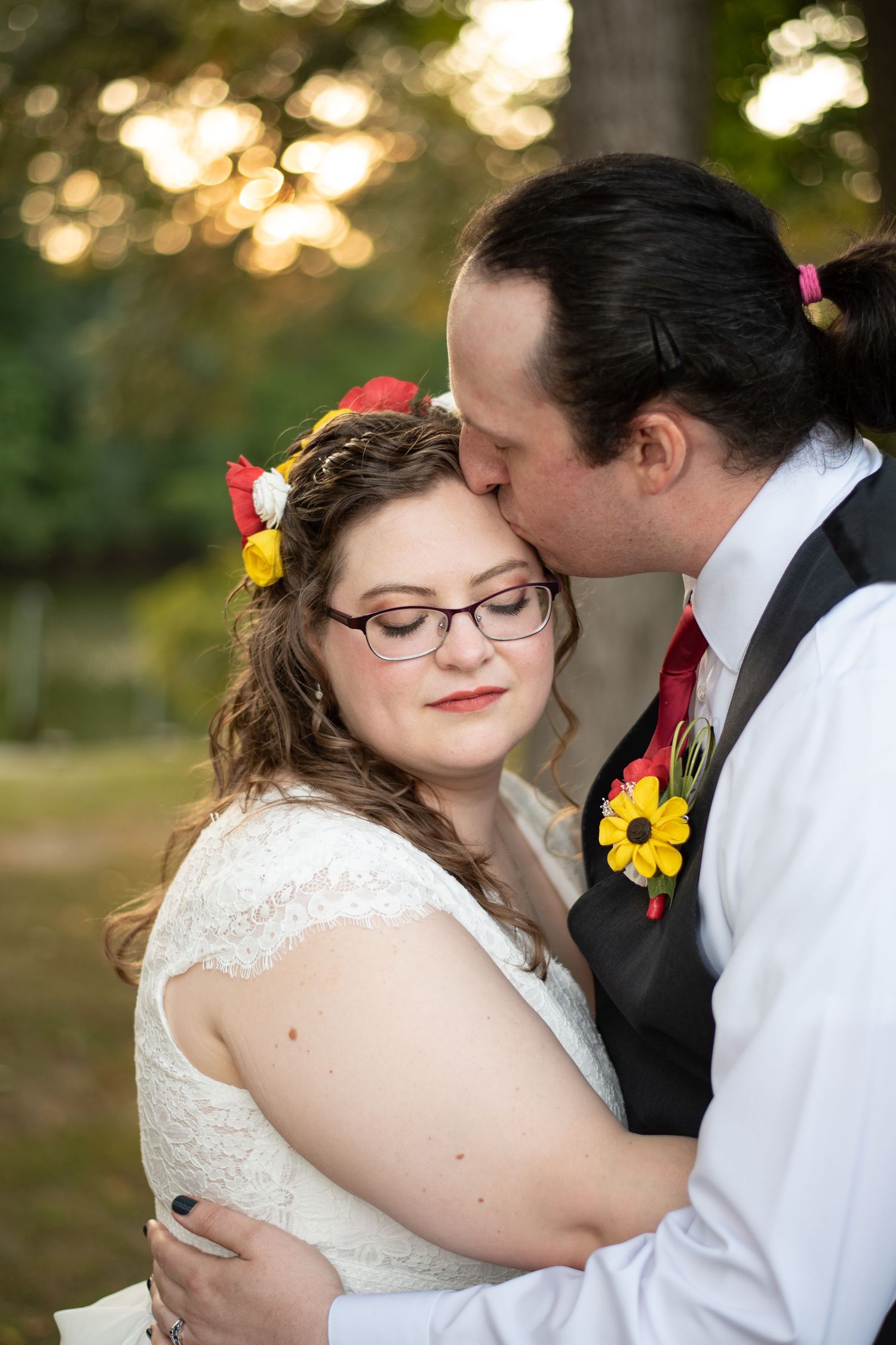 Wedding couple shares intimate moment with colorful floral details at outdoor autumn ceremony.