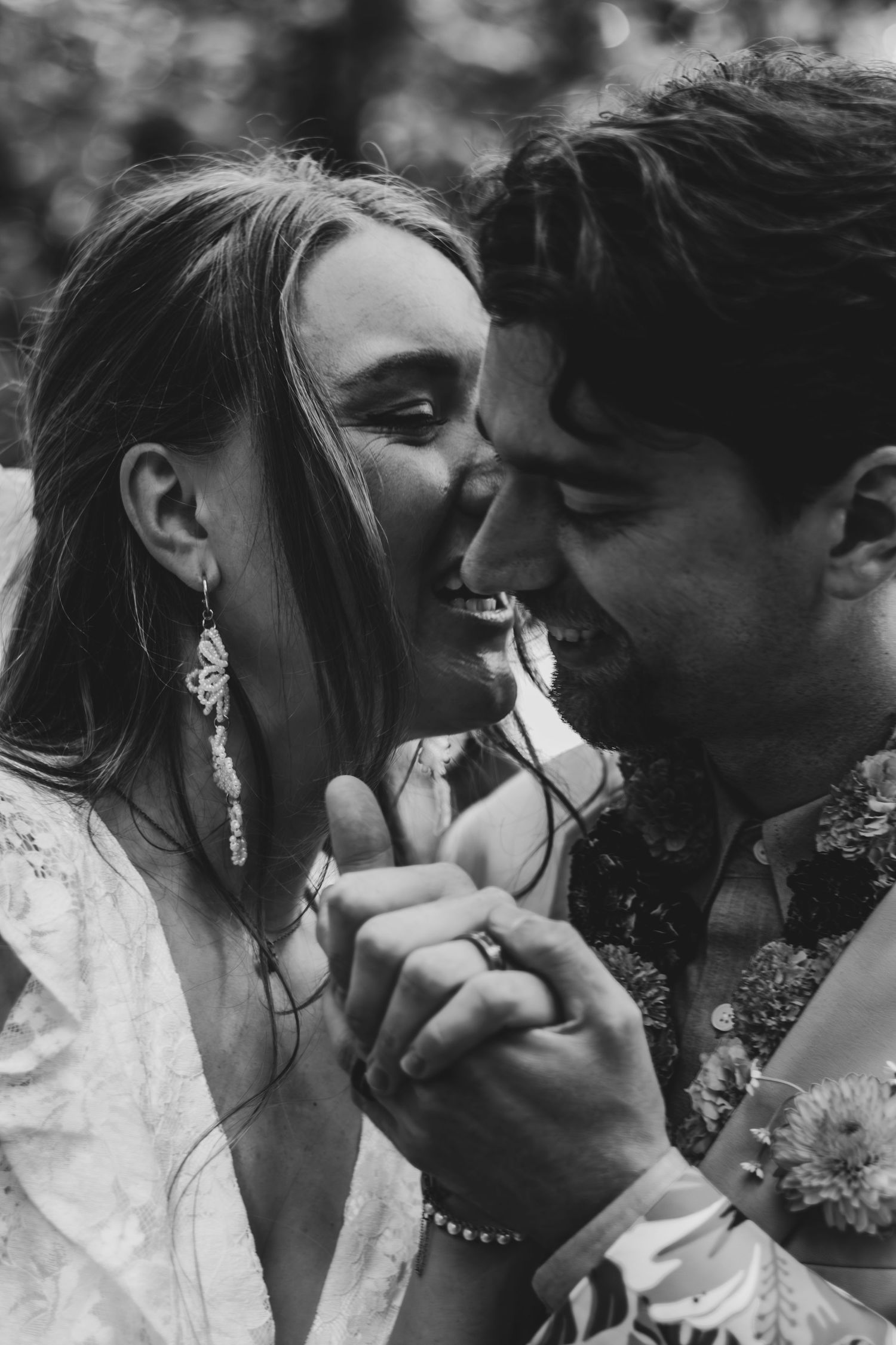 Black and white photo of laughing bride and groom sharing a joyful intimate moment on their wedding day.