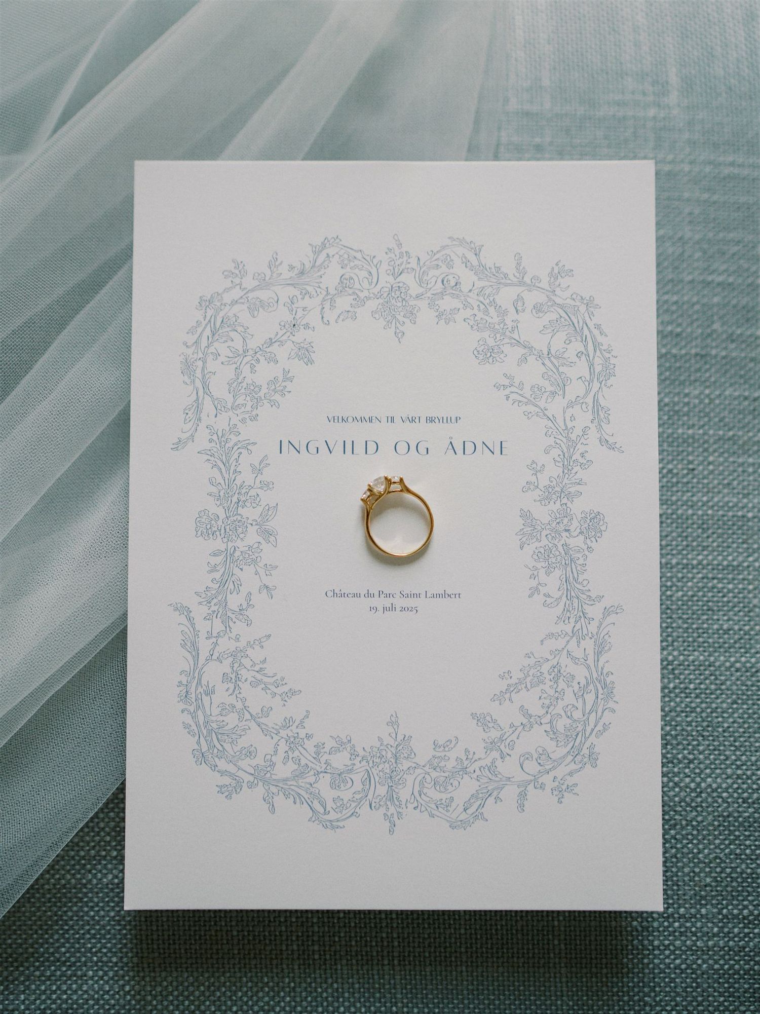 Classic wedding invitation for Ingvild og Adni with blue botanical border design and gold engagement ring.