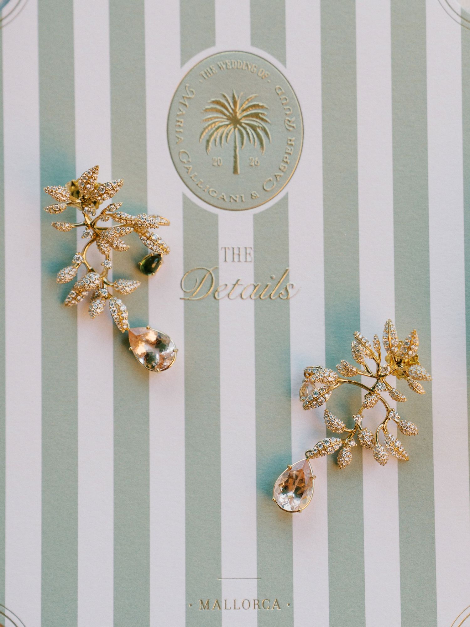 Gold floral crystal earrings displayed on a mint striped card reading The Details, Mallorca.