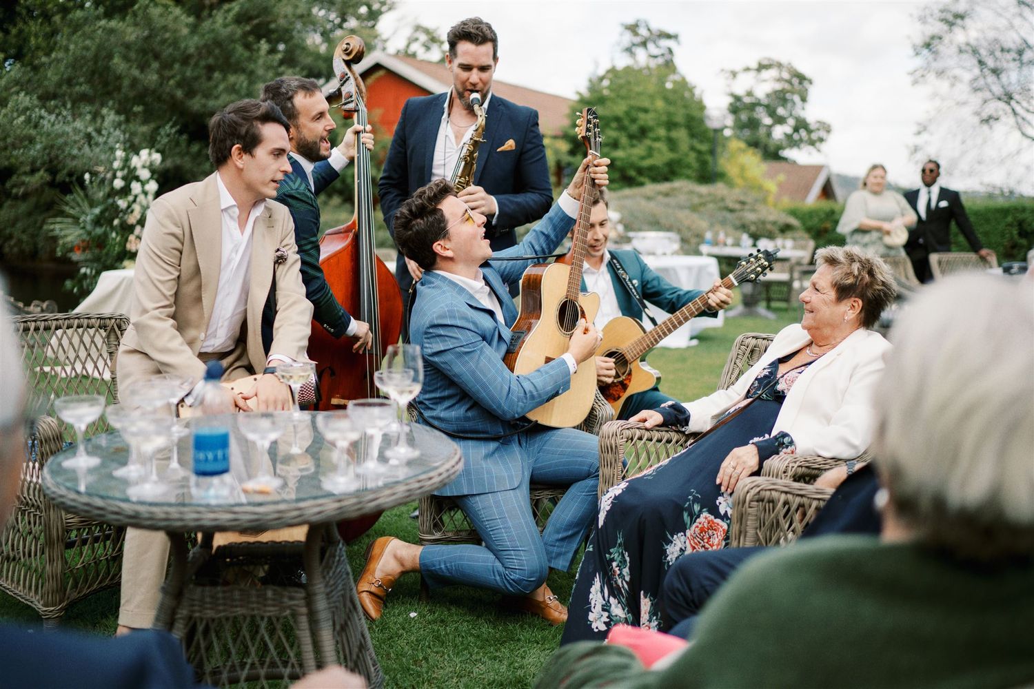 Live band performing with guitar and double bass at an outdoor garden wedding reception.