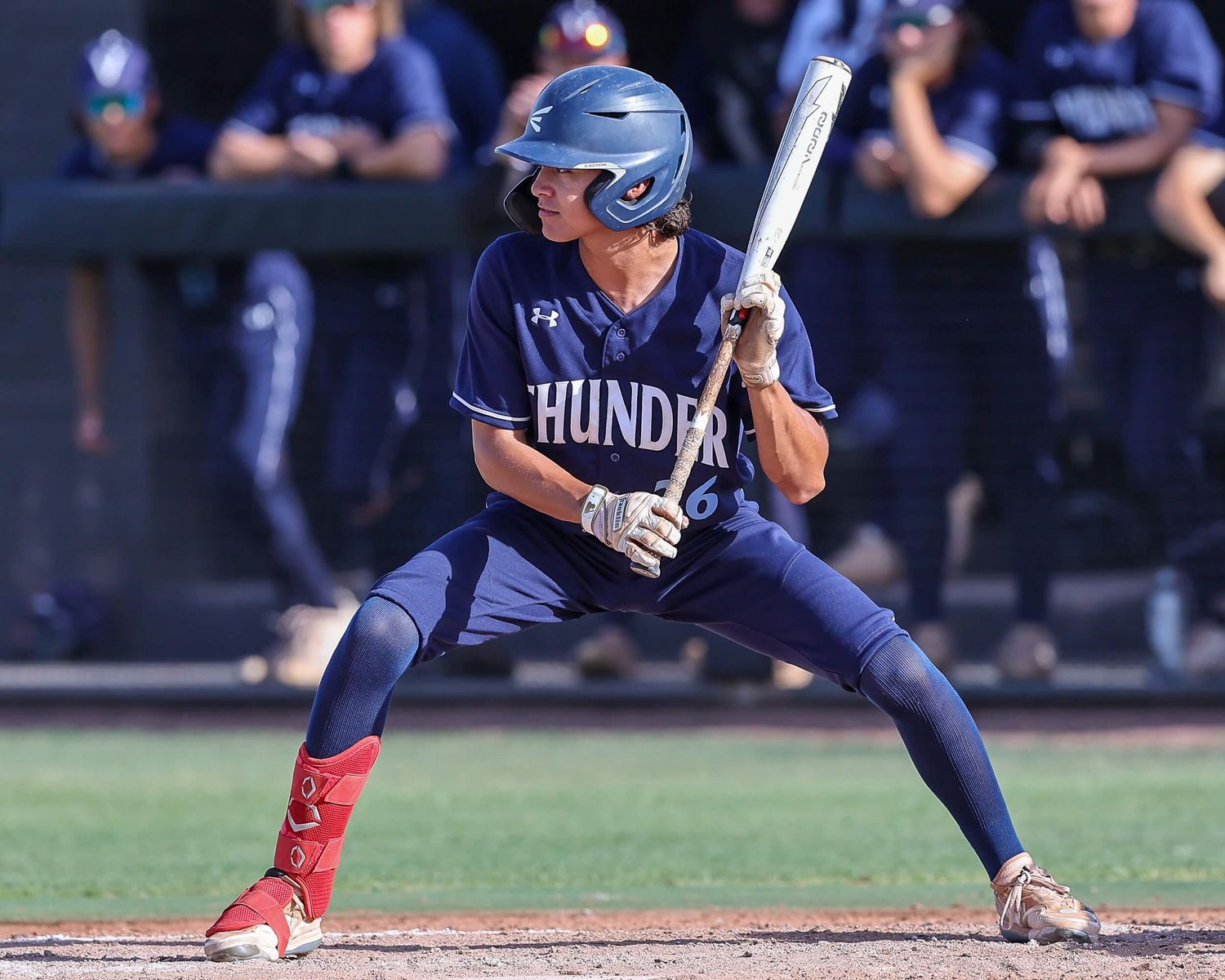 Female softball player in blue Thunder uniform preparing to bunt during a game.